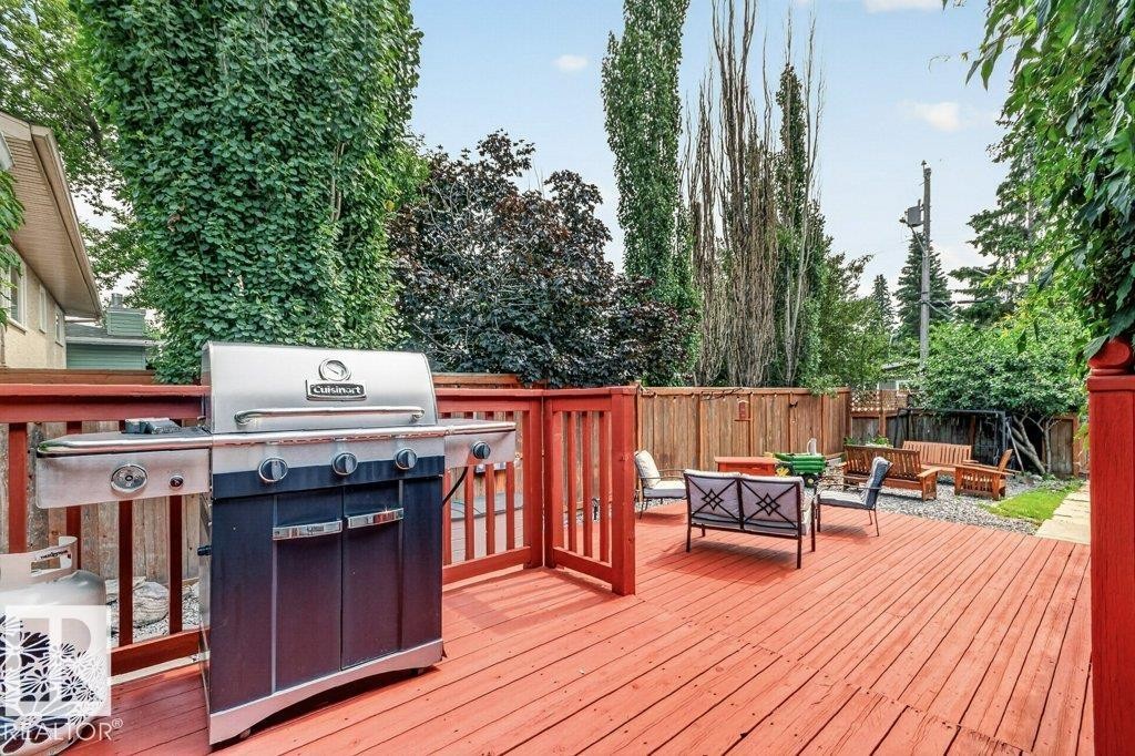 Expansive red-stained wood deck featuring a railing and gate - 11131 35A Avenue Nw, Edmonton, AB - Outdoor