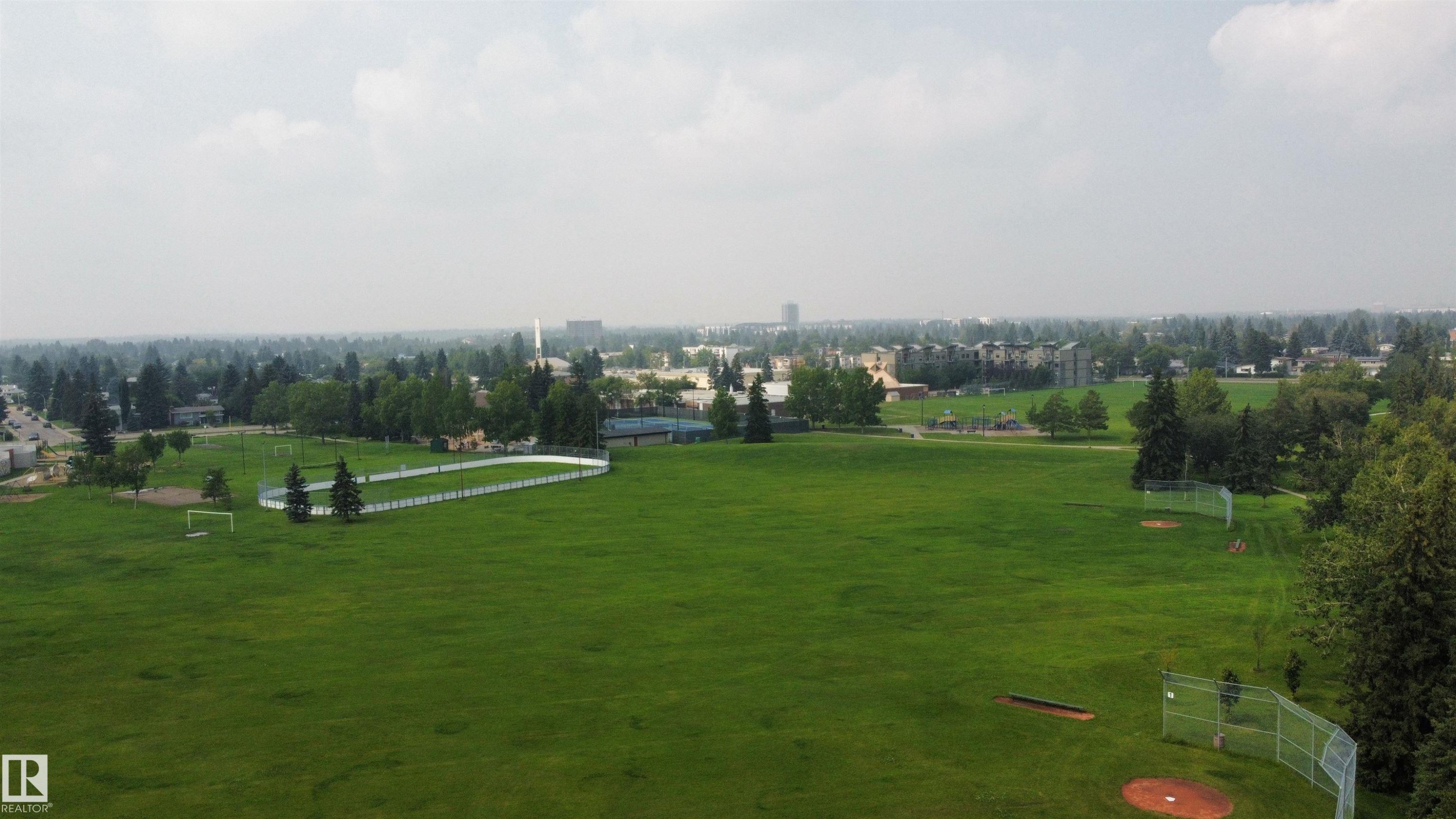 Expansive green space featuring large athletic fields, a designated baseball diamond with fencing, and a paved track - 11131 35A Avenue Nw, Edmonton, AB - Outdoor With View