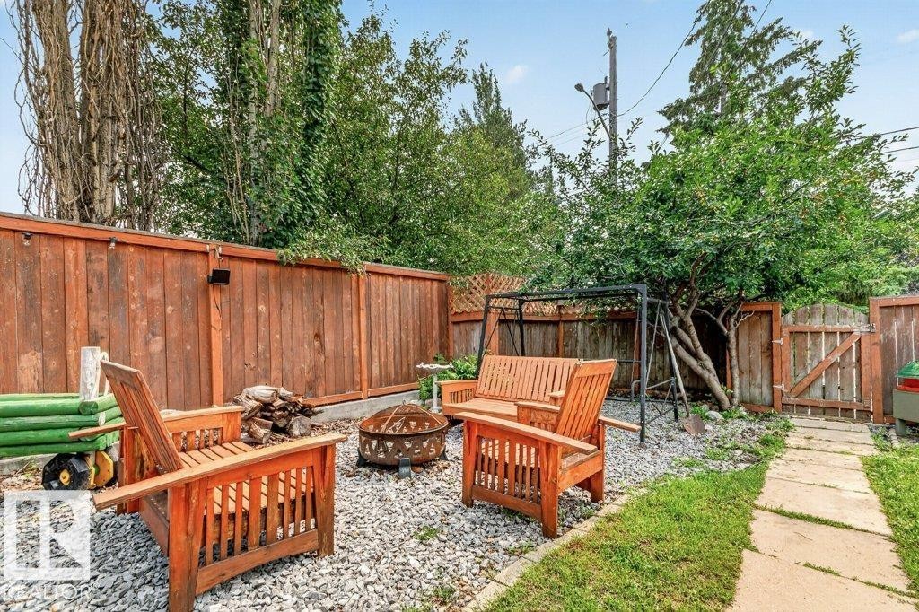 Gravel outdoor area featuring a fire pit, wood fencing, and a stepping stone pathway - 11131 35A Avenue Nw, Edmonton, AB - Outdoor