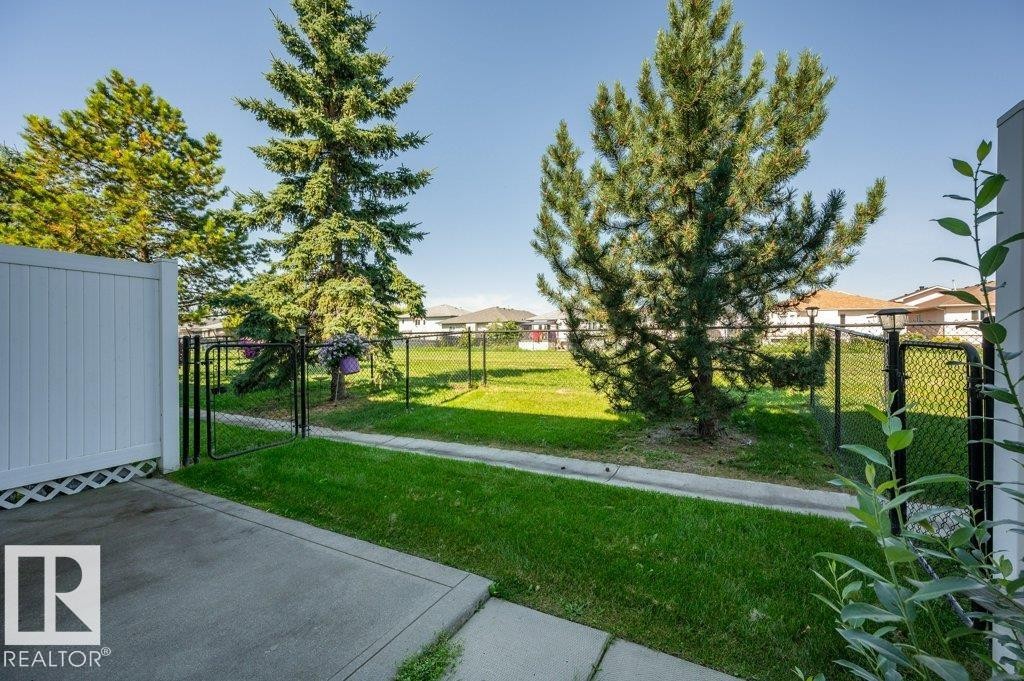Concrete patio with a white privacy fence - #26 2816 34 Av Nw, Edmonton, AB