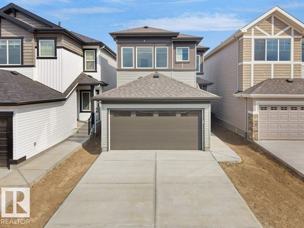 Contemporary exterior with multi-toned siding, attached front-facing garage, concrete driveway, and asphalt shingle roofing - 912 17 Ave Nw, Edmonton, AB
