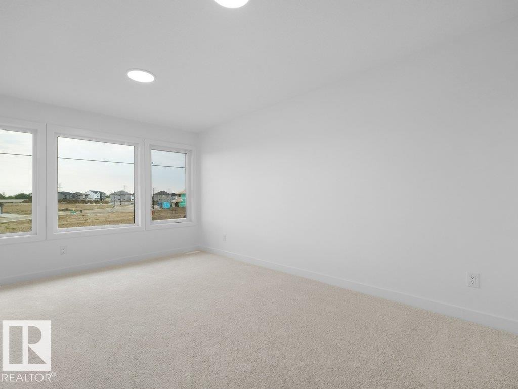 Recessed ceiling lighting, multiple large windows, neutral carpeting, and white wall finishes - 912 17 Ave Nw, Edmonton, AB