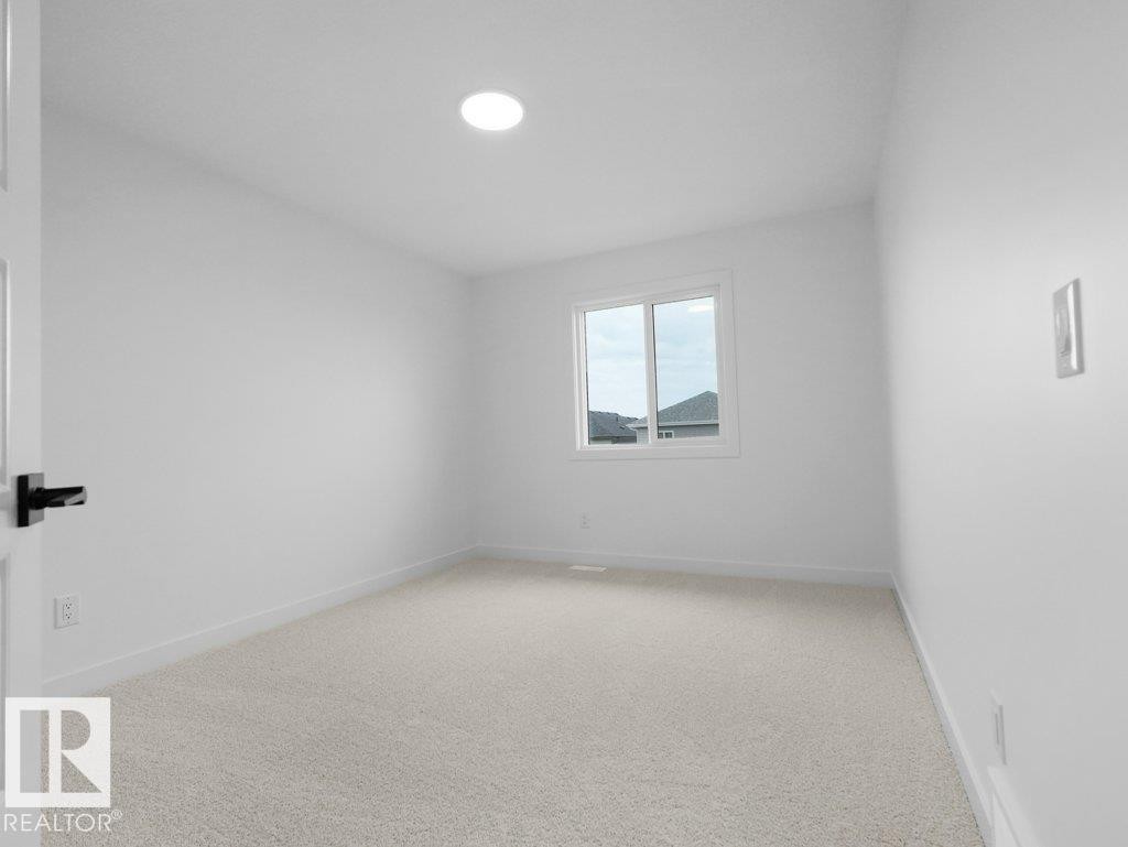 Recessed ceiling light, white painted walls, light-colored carpet, and a white framed window - 912 17 Ave Nw, Edmonton, AB