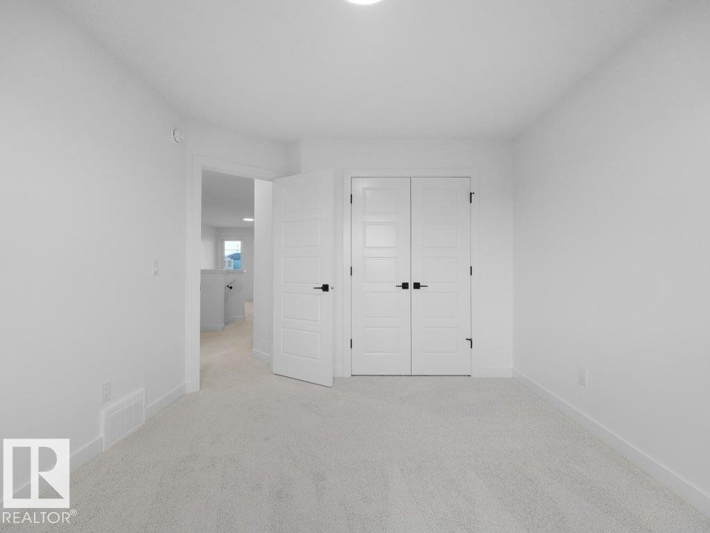 Neutral tone carpeting, white walls, and bright overhead lighting - 912 17 Ave Nw, Edmonton, AB