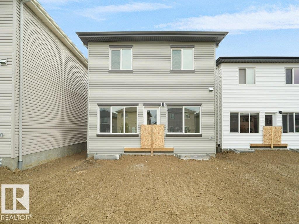 Two-story residence featuring light gray siding and a dark gray roofline - 912 17 Ave Nw, Edmonton, AB