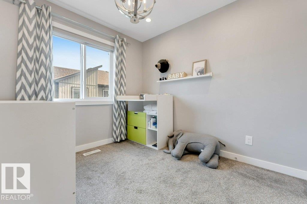 Wall-to-wall carpeting, single window with white trim, contemporary ceiling light fixture, neutral wall paint, and white baseboards - #45 16903 68 St Nw, Edmonton, AB