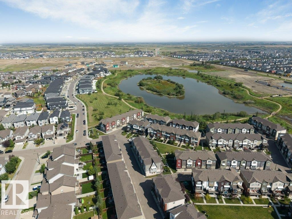 Expansive residential development with a central pond feature, surrounded by green spaces and walking paths - #45 16903 68 St Nw, Edmonton, AB