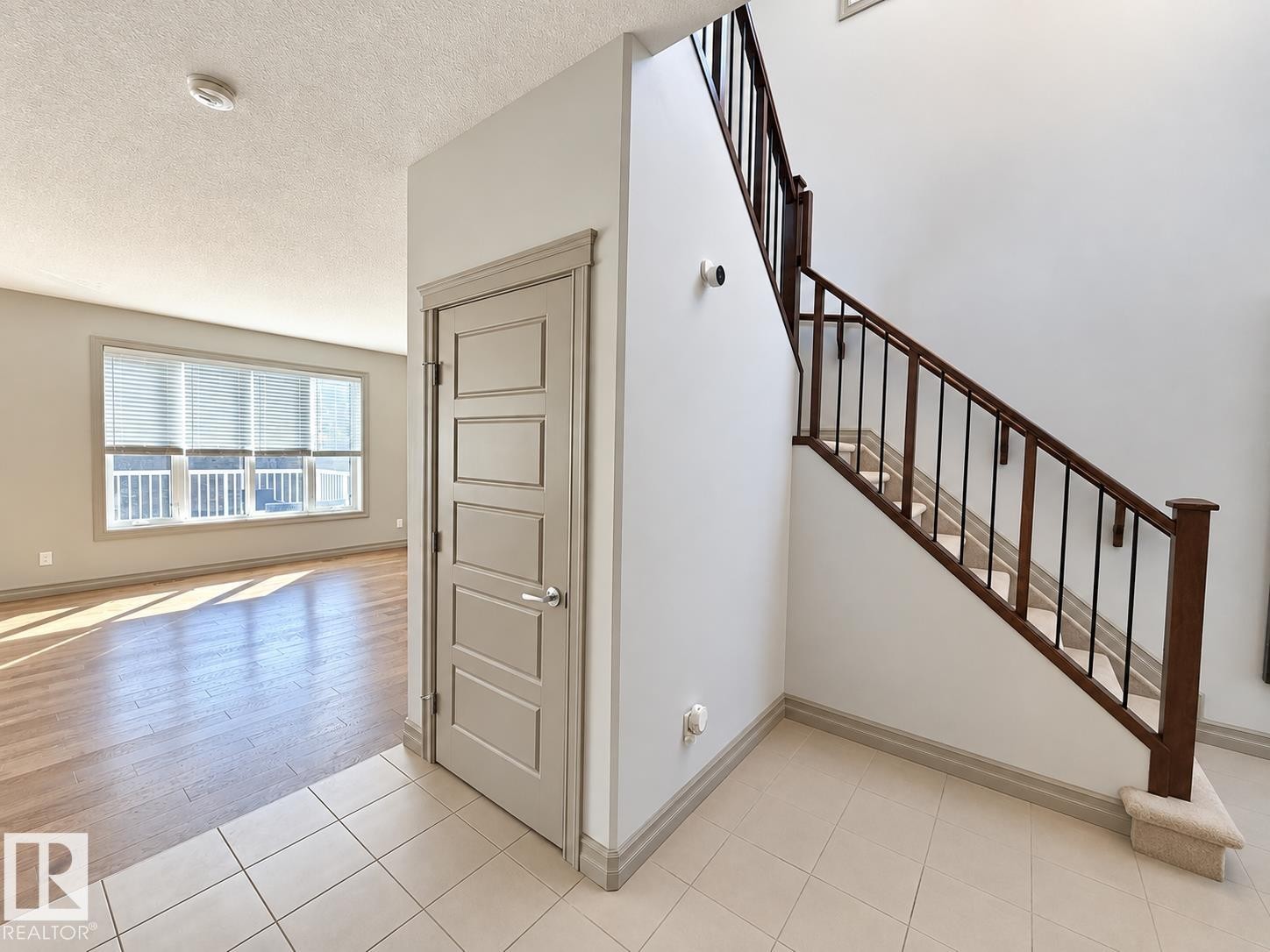 High ceilings and a bright interior featuring wood-finish flooring in the living area - 885 Windermere Wynd Nw, Edmonton, AB