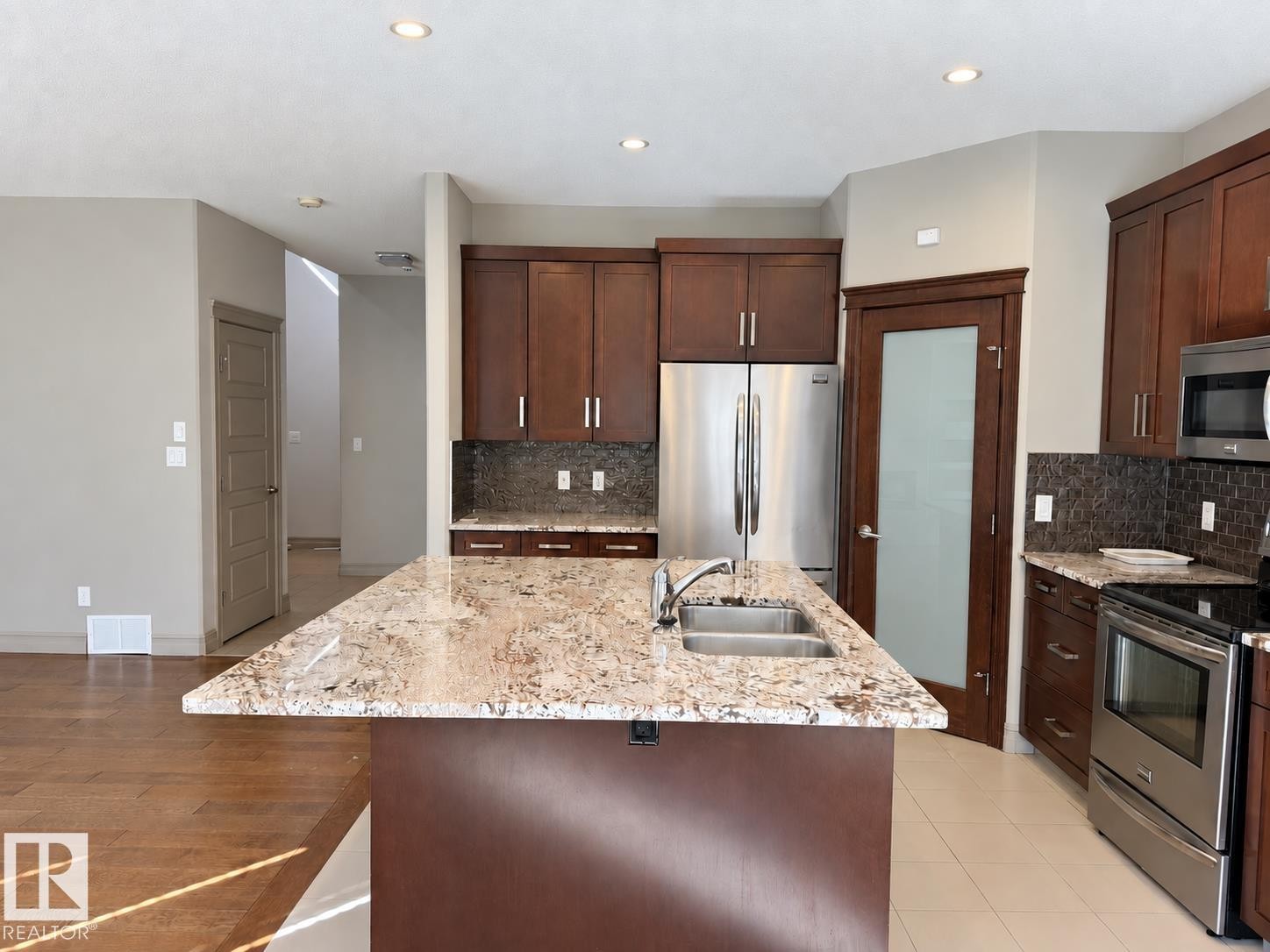 Kitchen island with granite countertop and double stainless steel sink - 885 Windermere Wynd Nw, Edmonton, AB