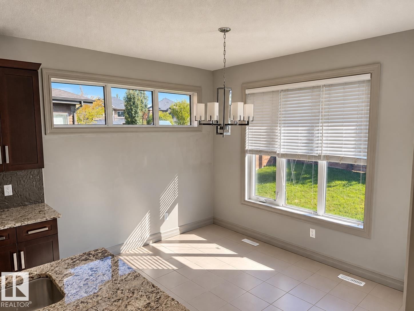 Recessed lighting, wood-finish cabinetry, granite countertops, tile flooring, and a contemporary chandelier - 885 Windermere Wynd Nw, Edmonton, AB