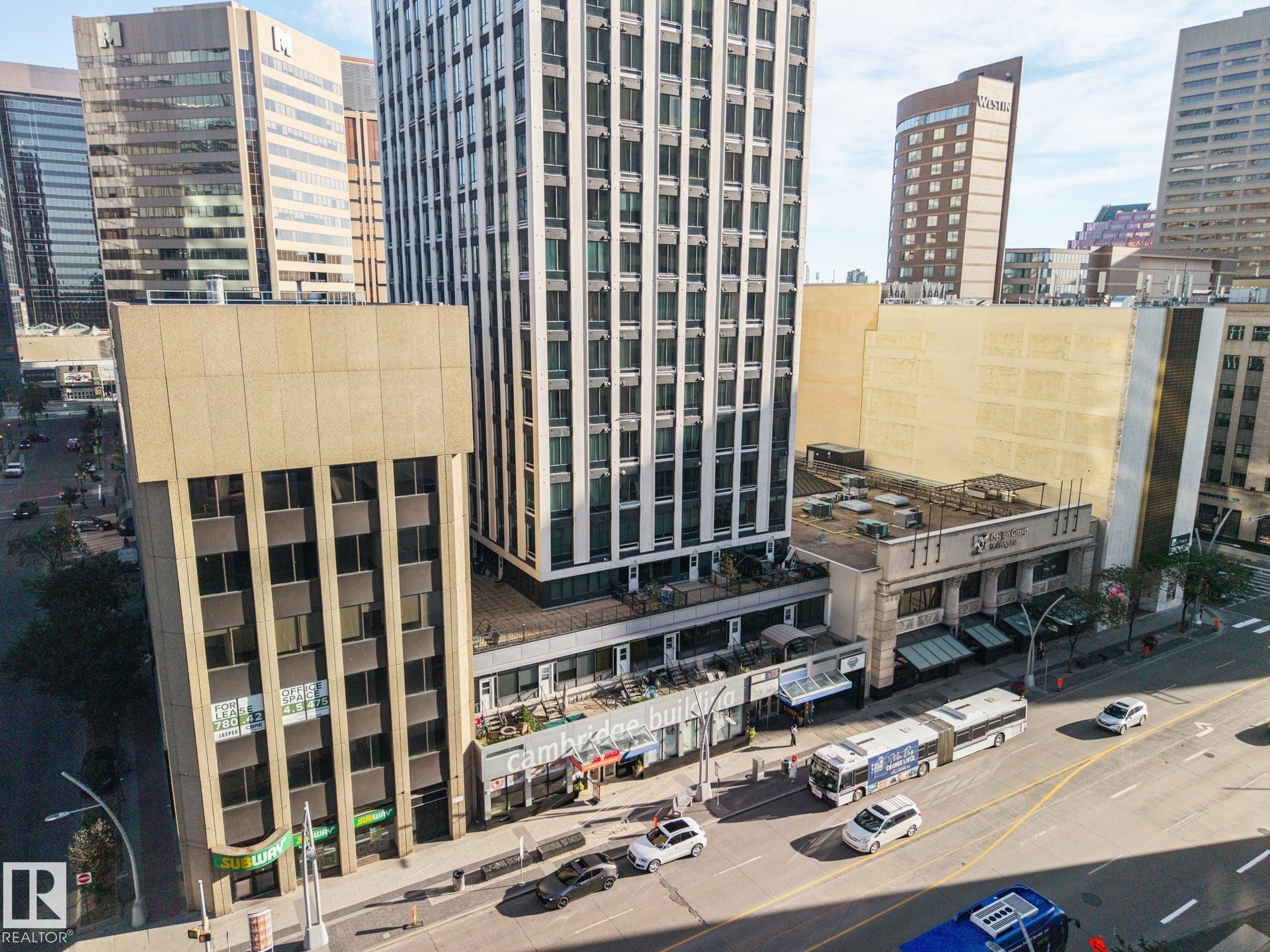 Urban streetscape with commercial buildings, a multi-story high-rise, and a busy thoroughfare - #1313 10024 Jasper Av Nw, Edmonton, AB