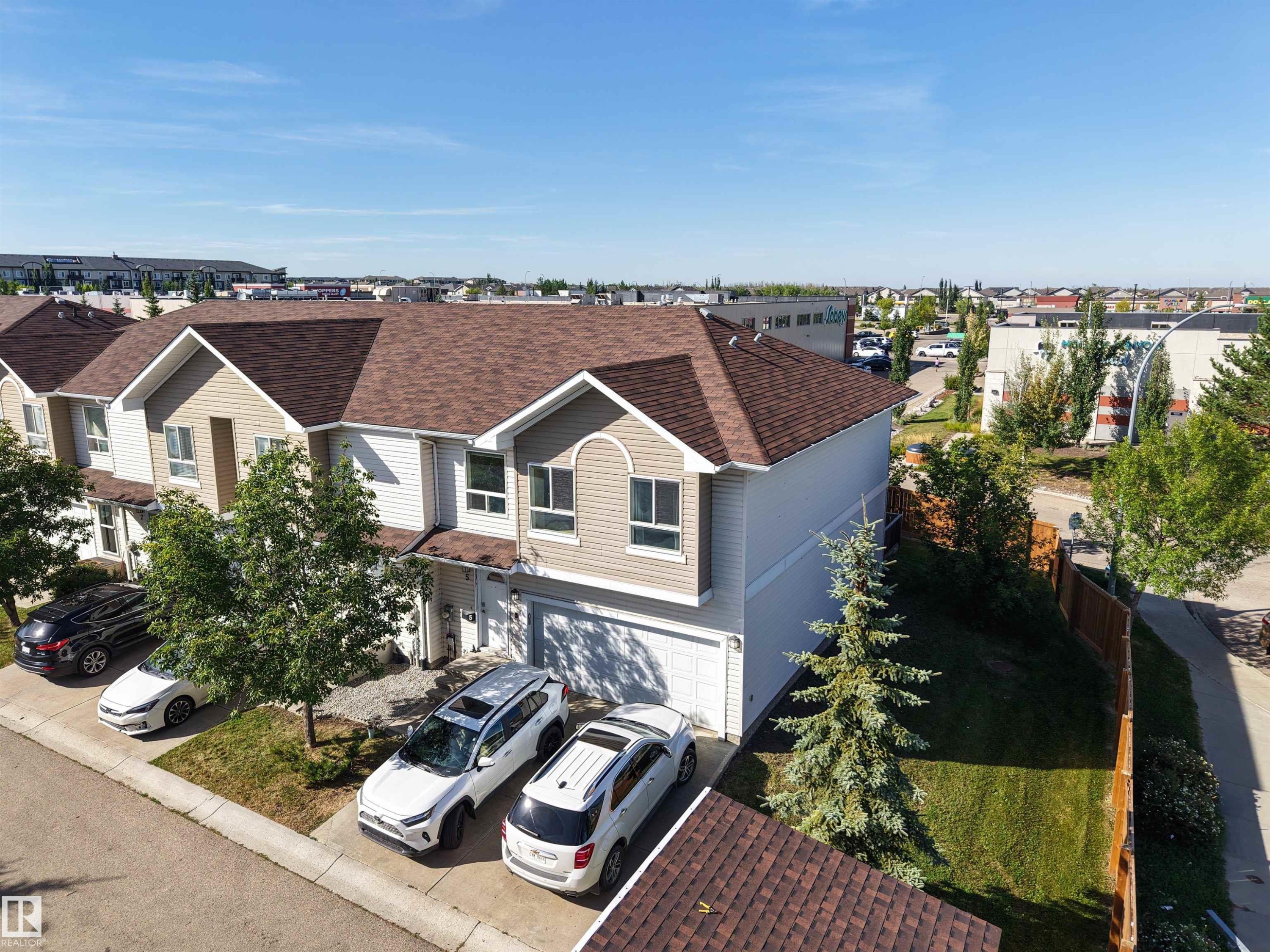 Two-story exterior with light-toned siding and a brown shingle roof - #5 5120 164 Av Nw, Edmonton, AB