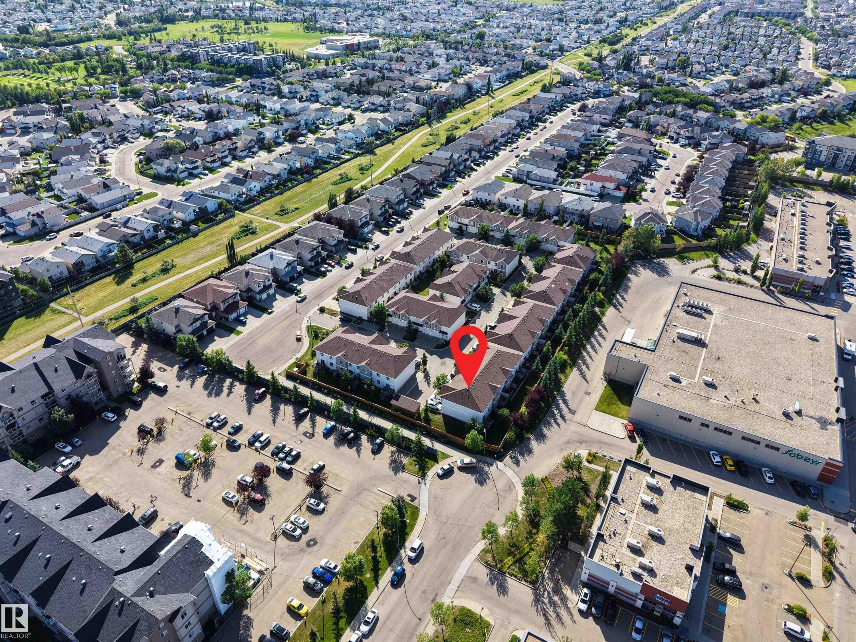 Aerial perspective showcasing the residential community, commercial buildings, and surrounding green spaces - #5 5120 164 Av Nw, Edmonton, AB