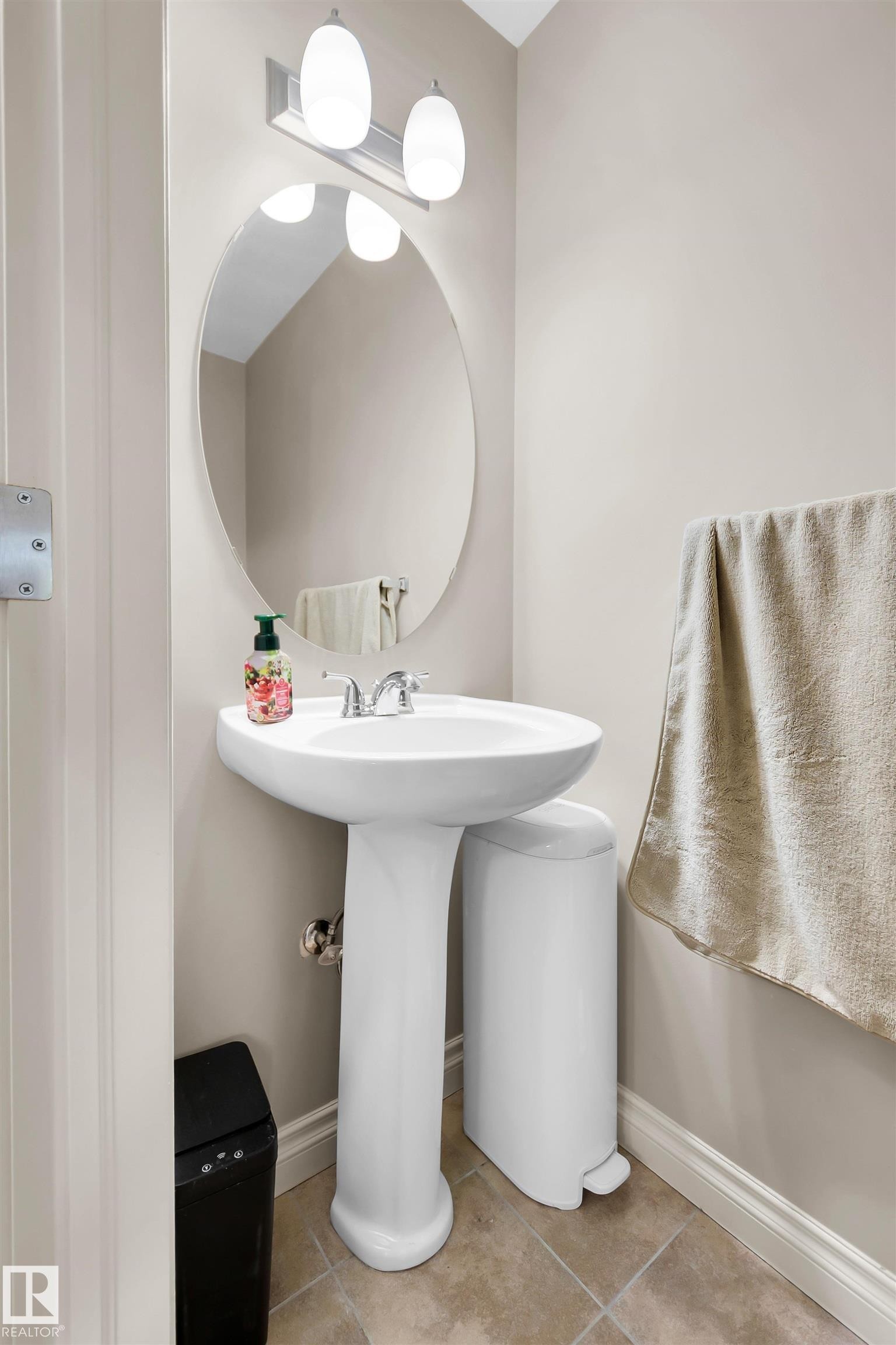 Pedestal sink with chrome faucet, oval mirror, and wall-mounted vanity light - #5 5120 164 Av Nw, Edmonton, AB