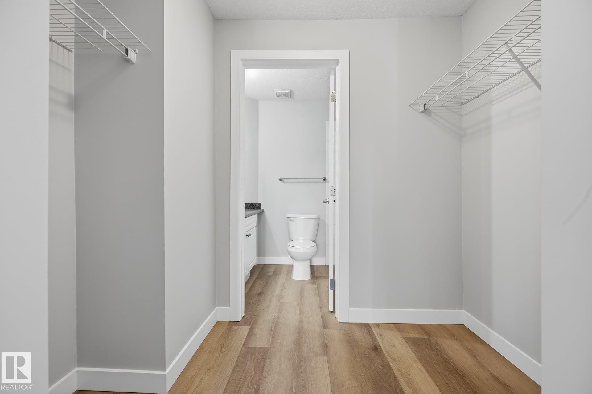Walk-in closet with wire shelving and wood-finish flooring - #122 240 Spruce Ridge Rd, Spruce Grove, AB