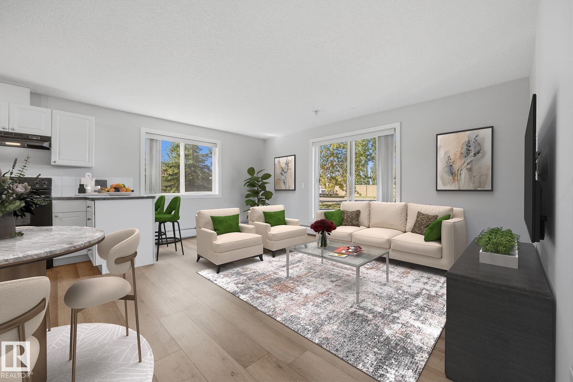 Open-concept living area with wood-finish flooring, white cabinetry, a kitchen island, and a sliding glass door - #122 240 Spruce Ridge Rd, Spruce Grove, AB