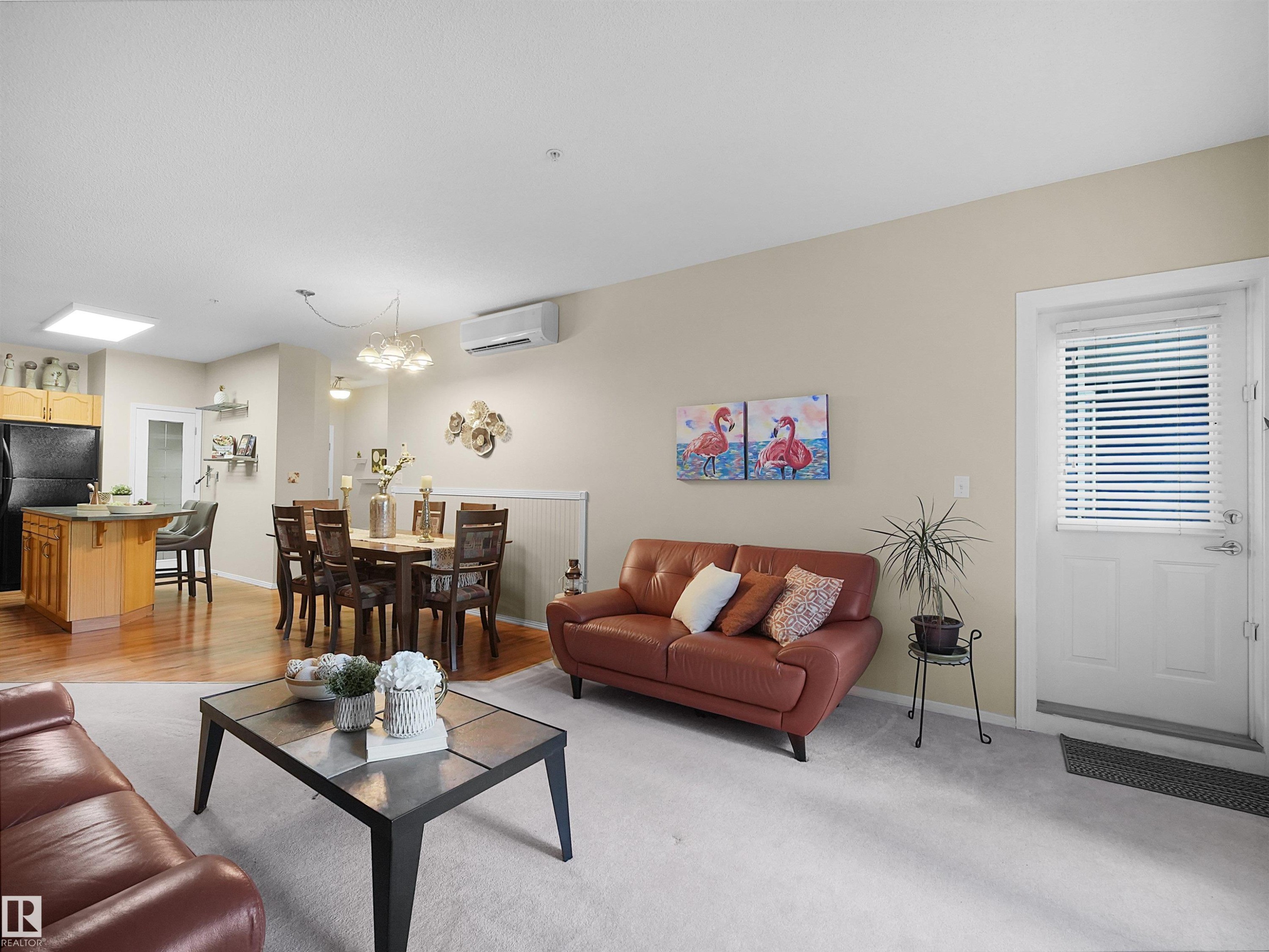 Open-concept living space featuring wood-finish flooring, light-toned walls, and recessed lighting - #206 12111 51 Av Nw, Edmonton, AB