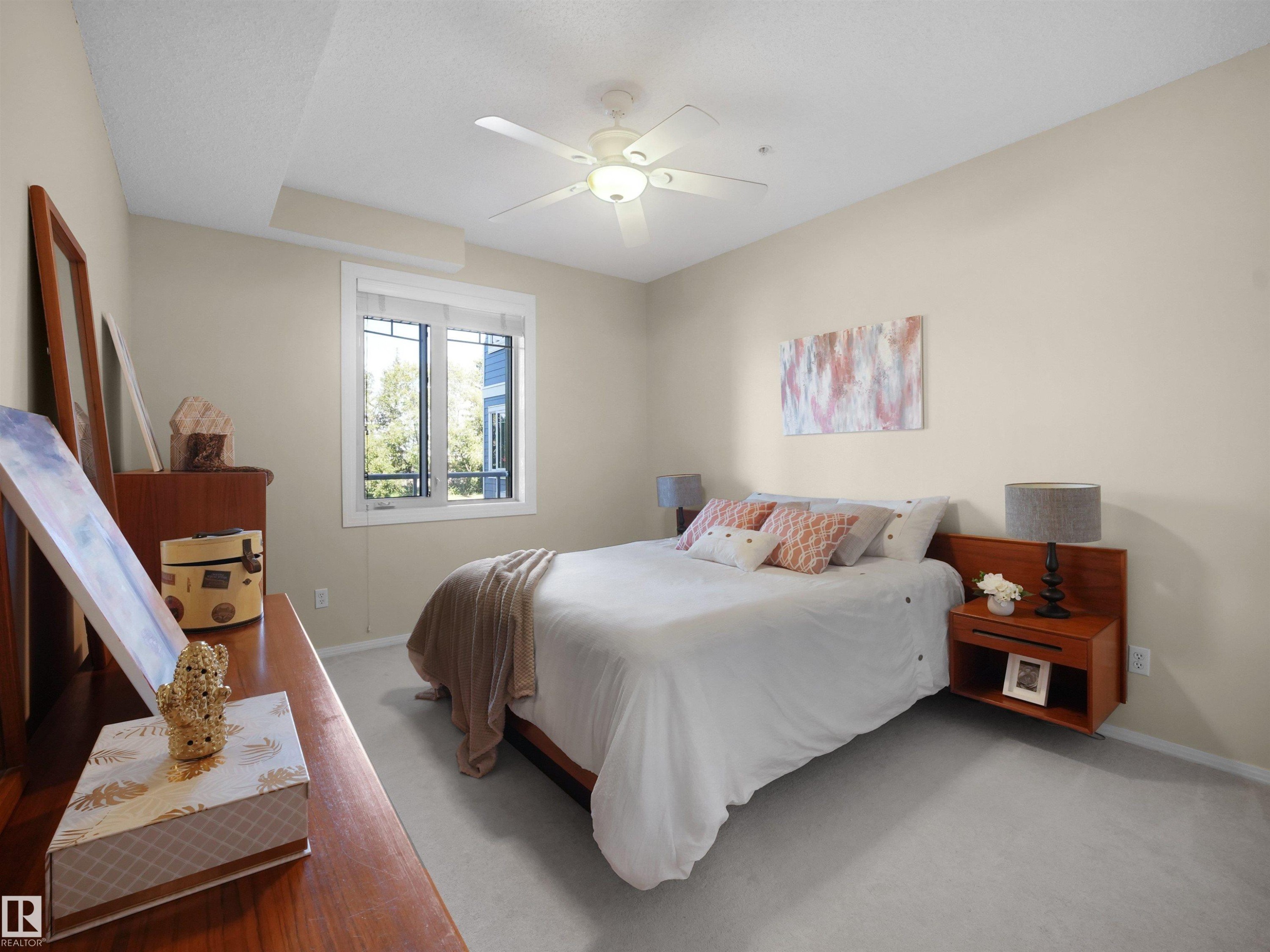 Recessed window with white trim, ceiling fan light fixture, light neutral wall paint, and gray carpeting - #206 12111 51 Av Nw, Edmonton, AB