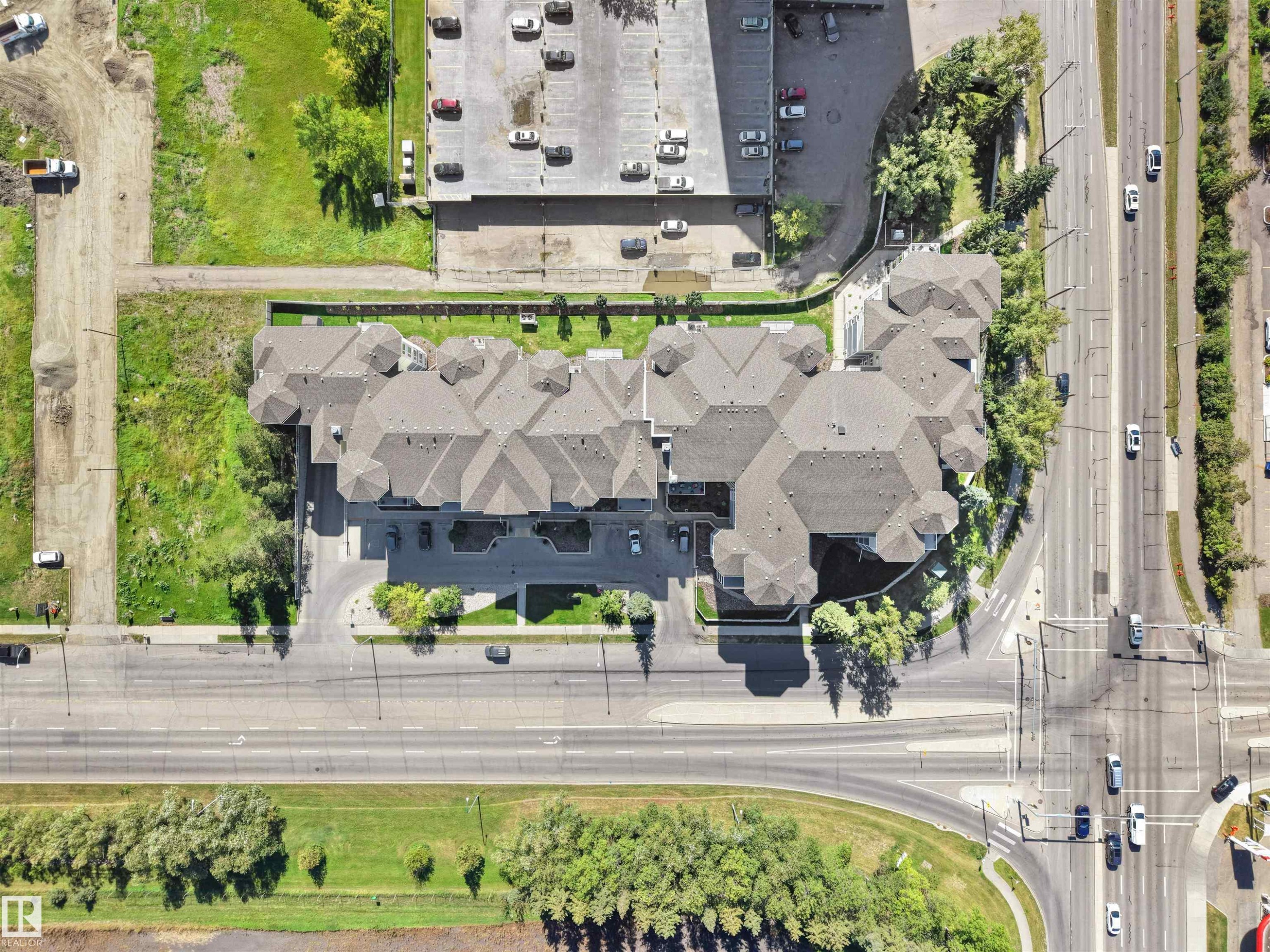 Extensive multi-unit residential property with complex rooflines, surrounded by paved roadways and mature landscaping - #206 12111 51 Av Nw, Edmonton, AB