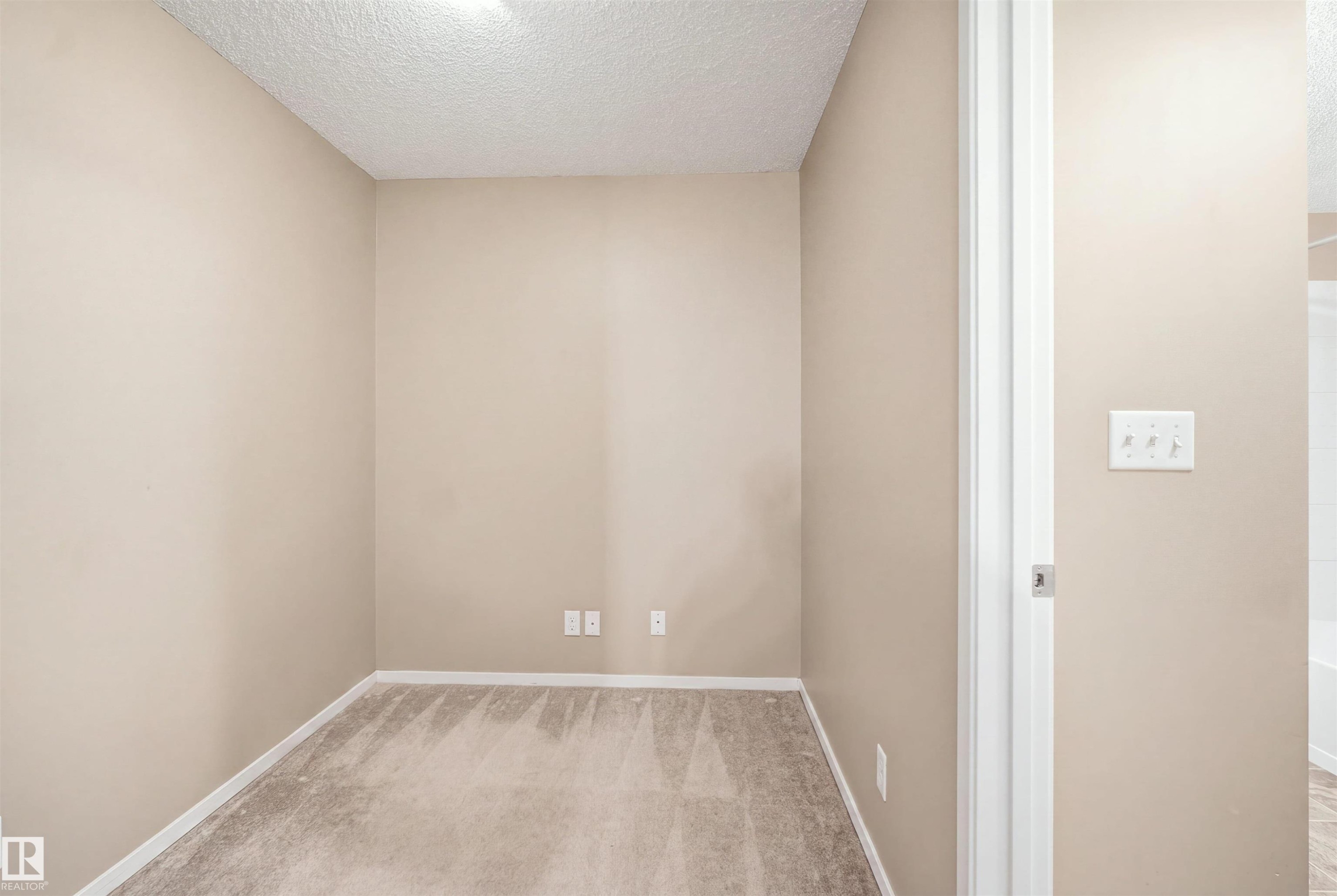 Neutral-toned walls, textured ceiling, and carpeting - #225 1510 Watt Dr Sw, Edmonton, AB