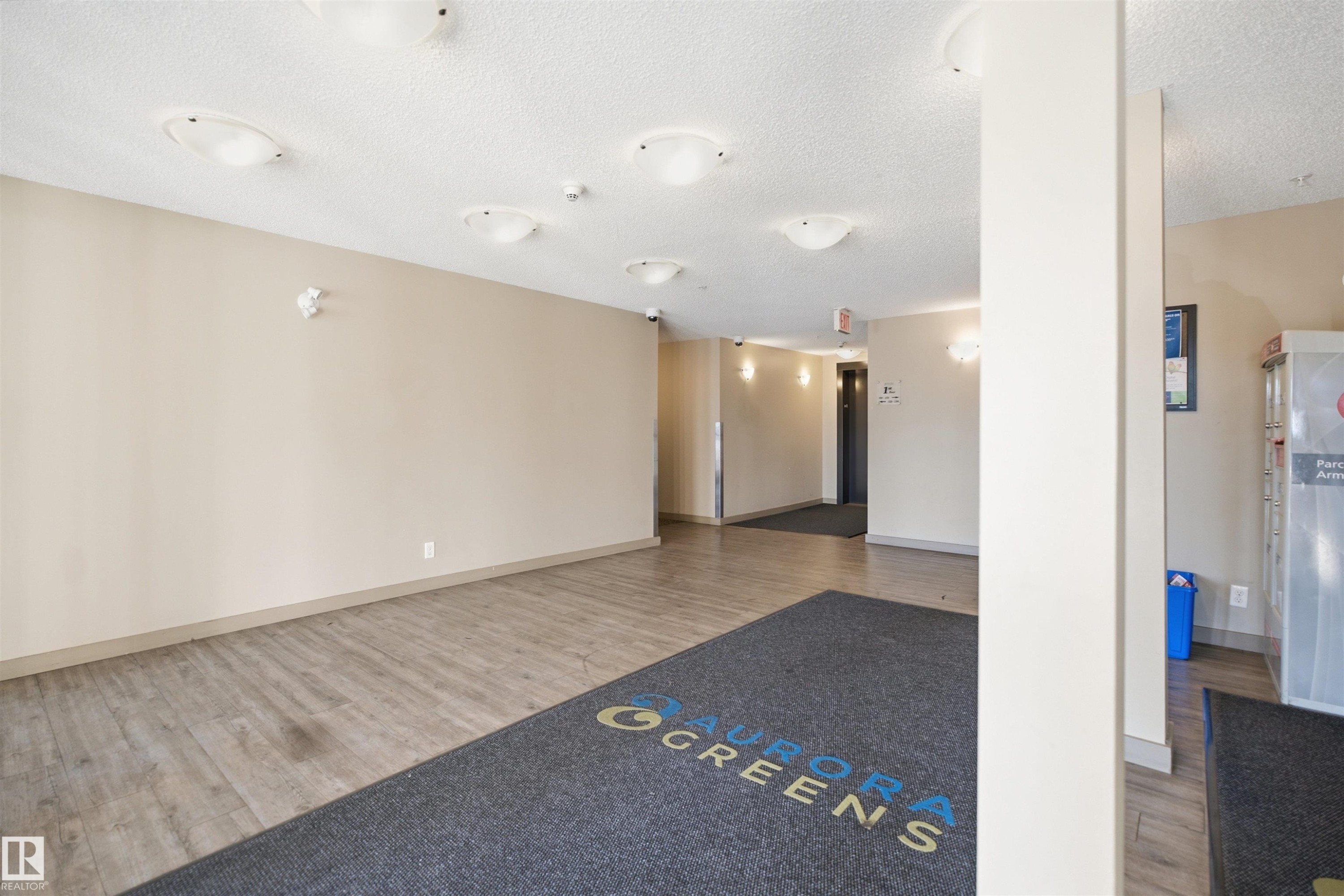 Wood-finish flooring with a textured ceiling and recessed lighting - #225 1510 Watt Dr Sw, Edmonton, AB