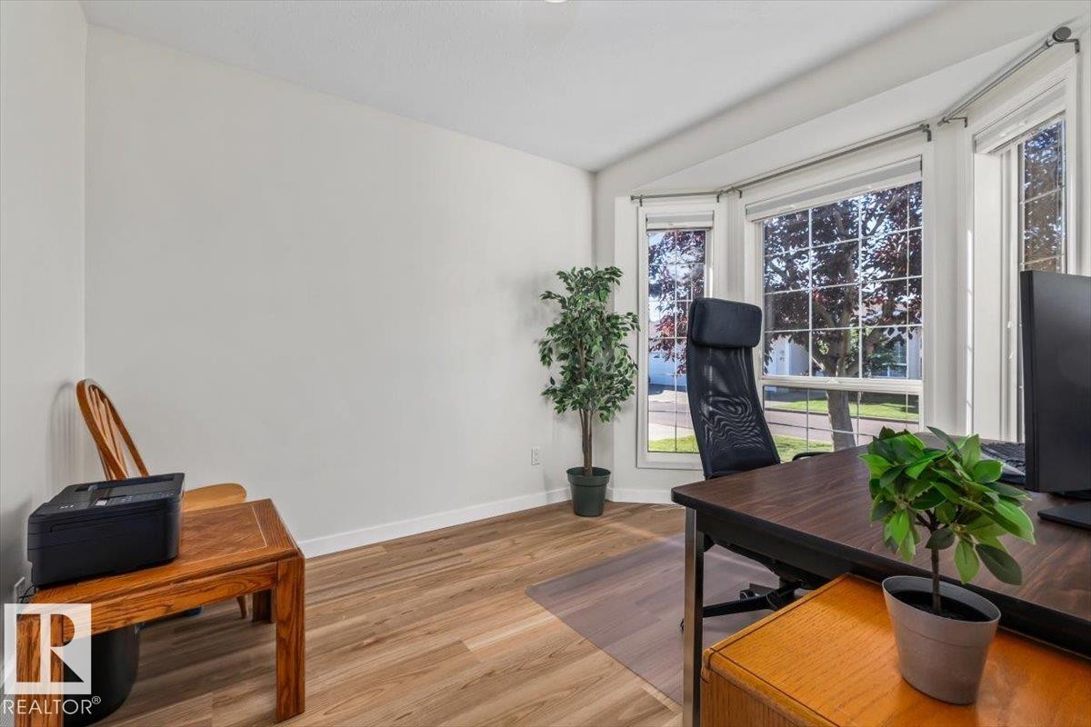Bay window with multiple panes, wood-finish flooring, and white walls - #92 13320 124 St Nw, Edmonton, AB