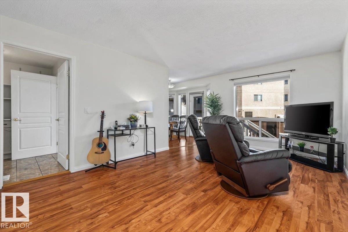 Wood-finish flooring throughout, white walls, and a large window with white trim - #92 13320 124 St Nw, Edmonton, AB