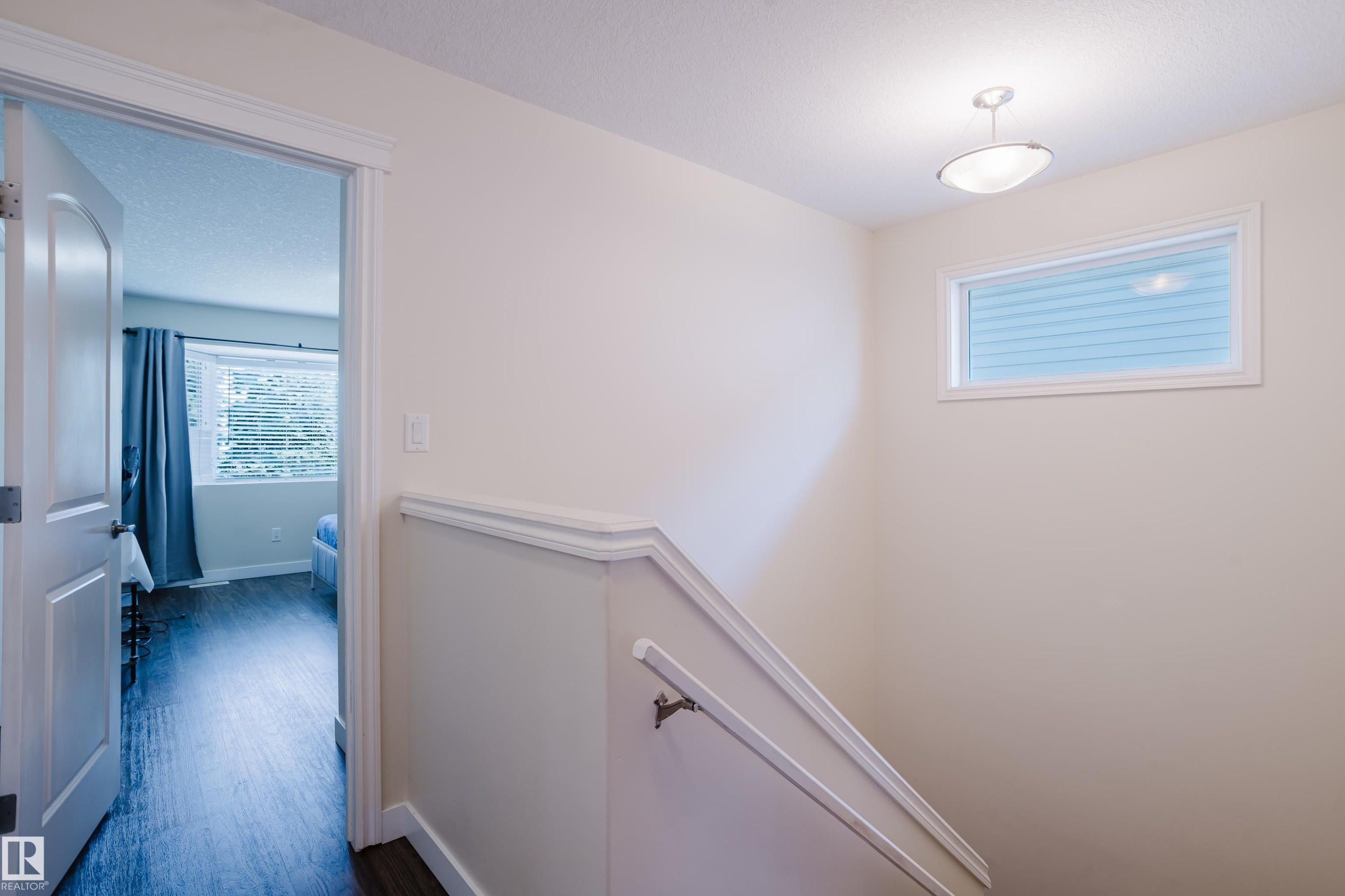 White interior walls and trim, wood-finish flooring, and a flush-mount ceiling light - 10332 161 Street Nw, Edmonton, AB