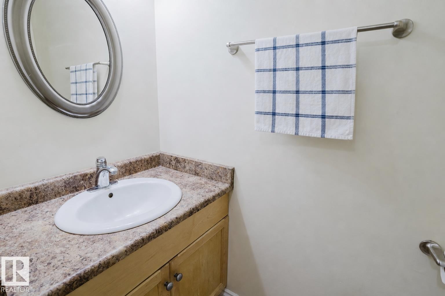 Oval undermount sink with chrome faucet, set into a stone-look countertop - 10332 161 Street Nw, Edmonton, AB