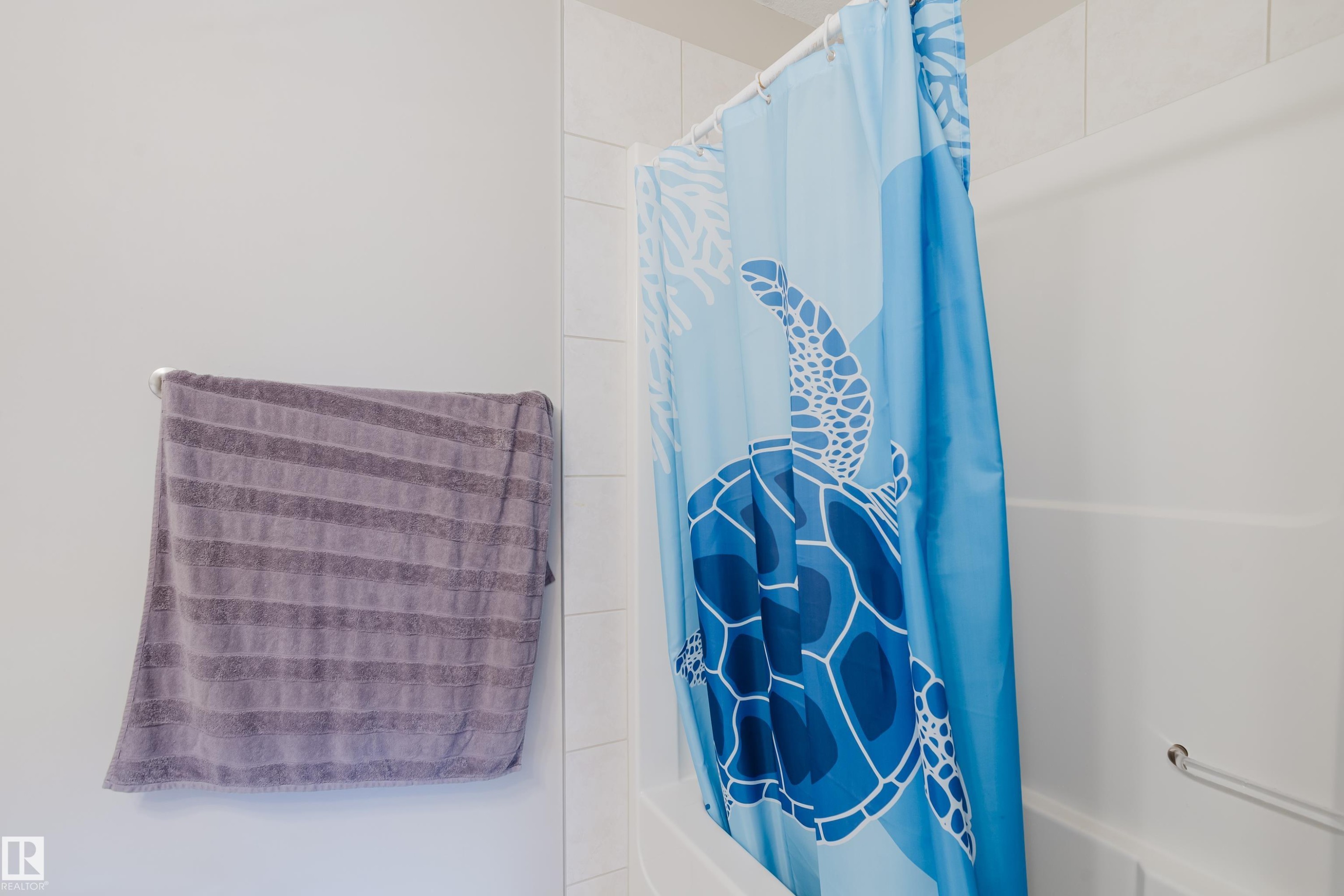 White tiled shower surround with an integrated white bathtub and a chrome grab bar - 10334 161 Street Nw, Edmonton, AB