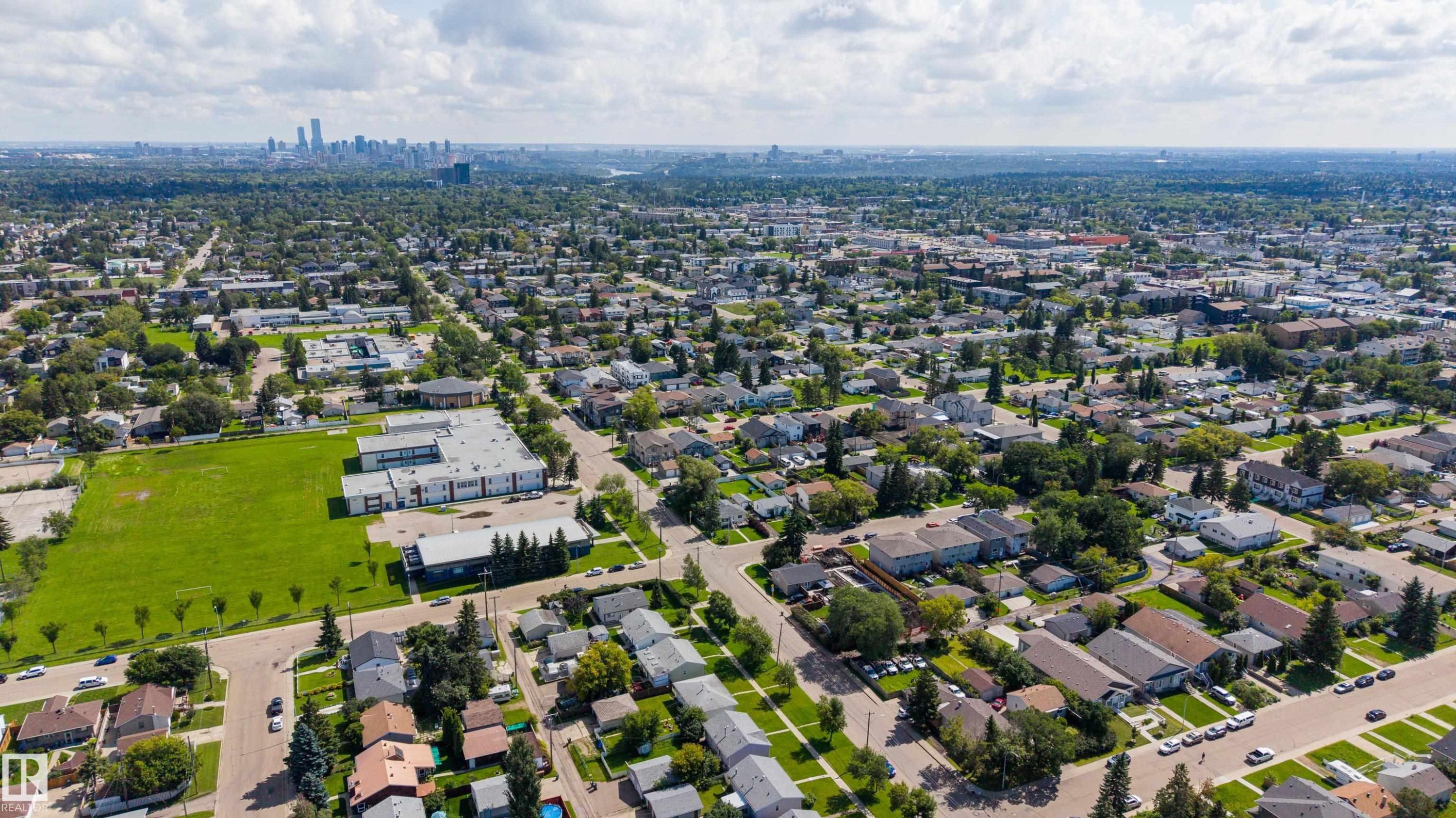 Expansive urban landscape featuring a distant skyline, residential neighborhoods with mature trees, and a visible commercial area - 10334 161 Street Nw, Edmonton, AB