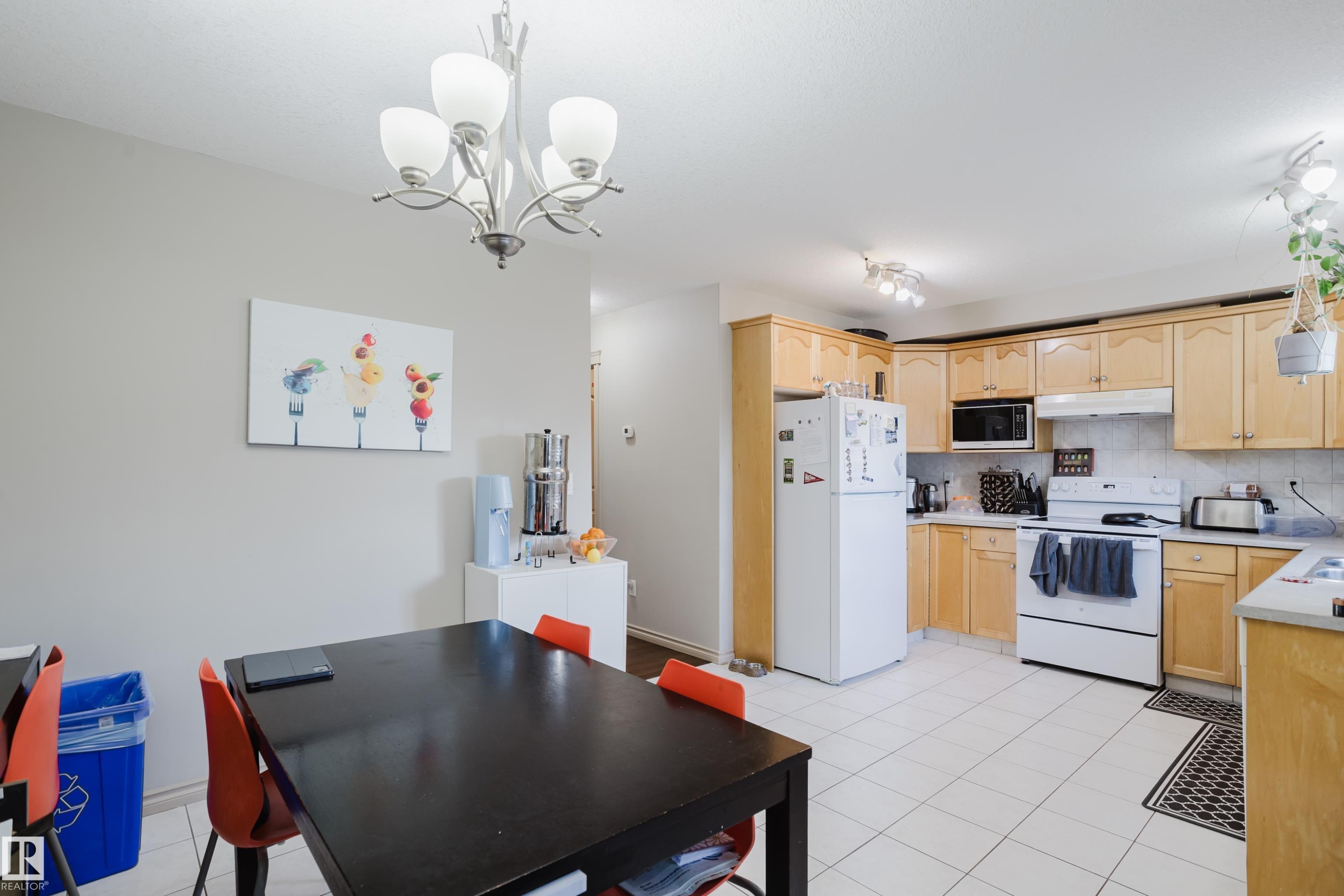 Kitchen featuring wood-finish cabinetry, white appliances, and track lighting - 10334 161 Street Nw, Edmonton, AB