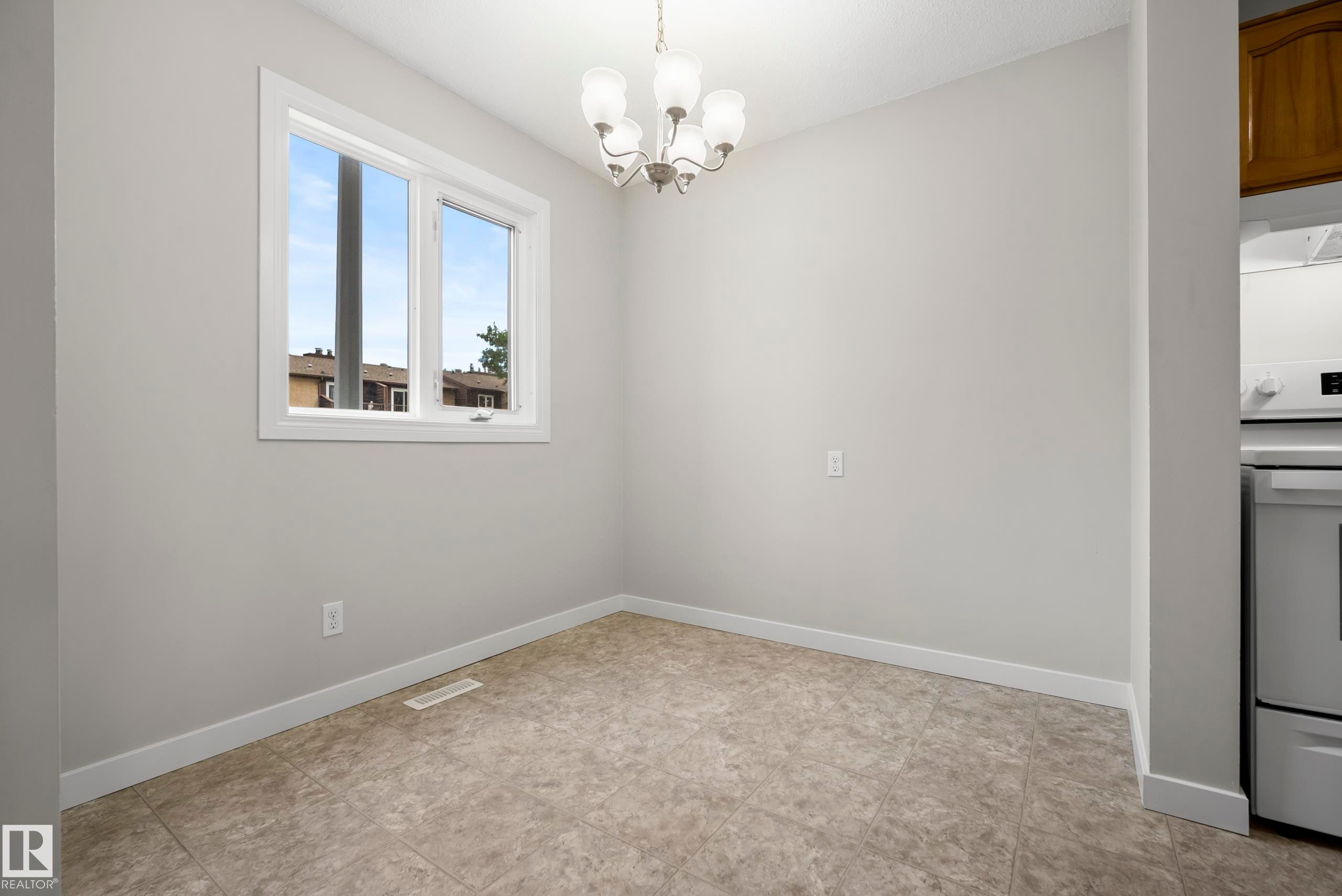 Neutral wall color, tiled flooring, white-framed window, and a ceiling-mounted light fixture - 3173 139 Avenue Nw, Edmonton, AB