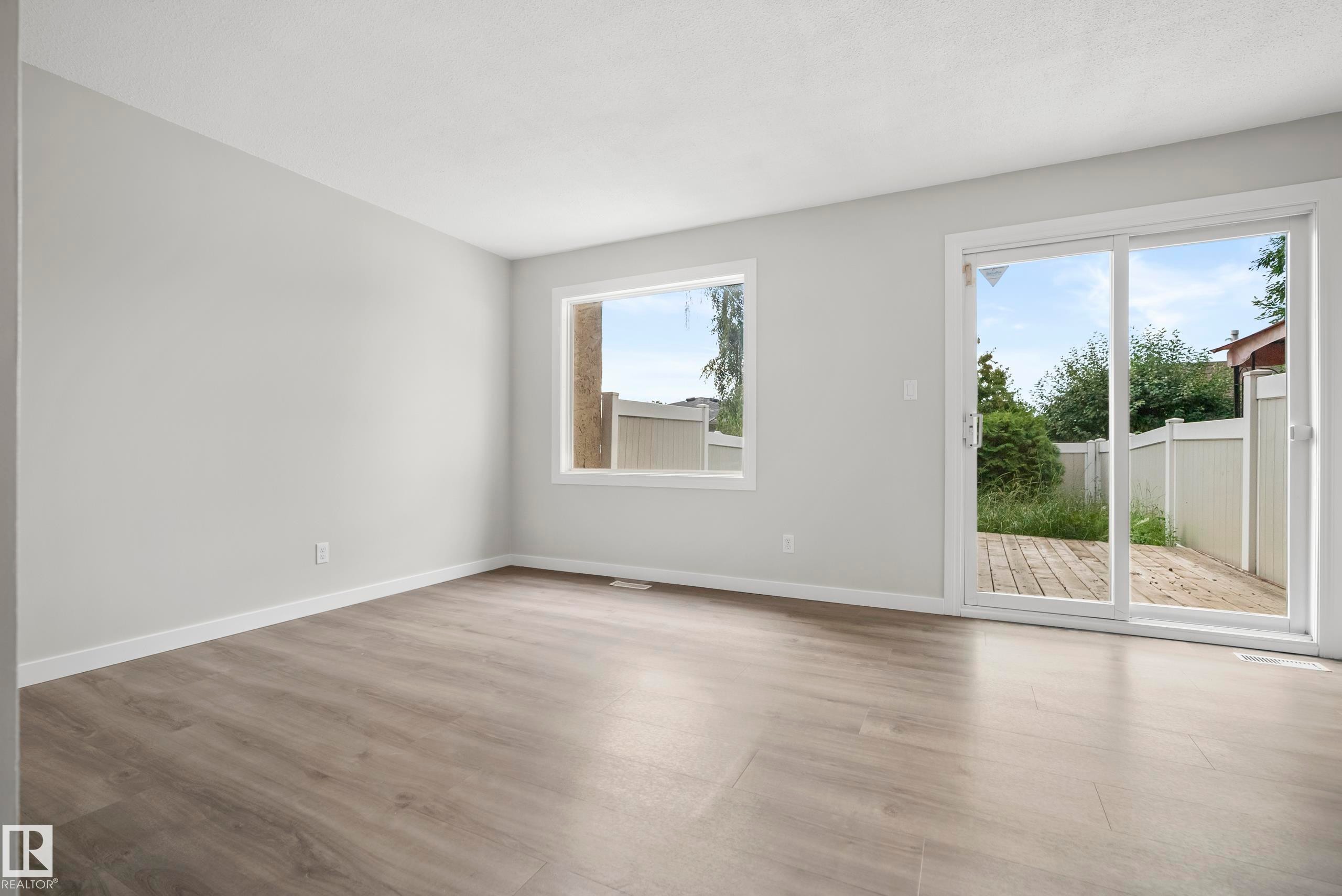 Wood-finish flooring with white trim - 3173 139 Avenue Nw, Edmonton, AB