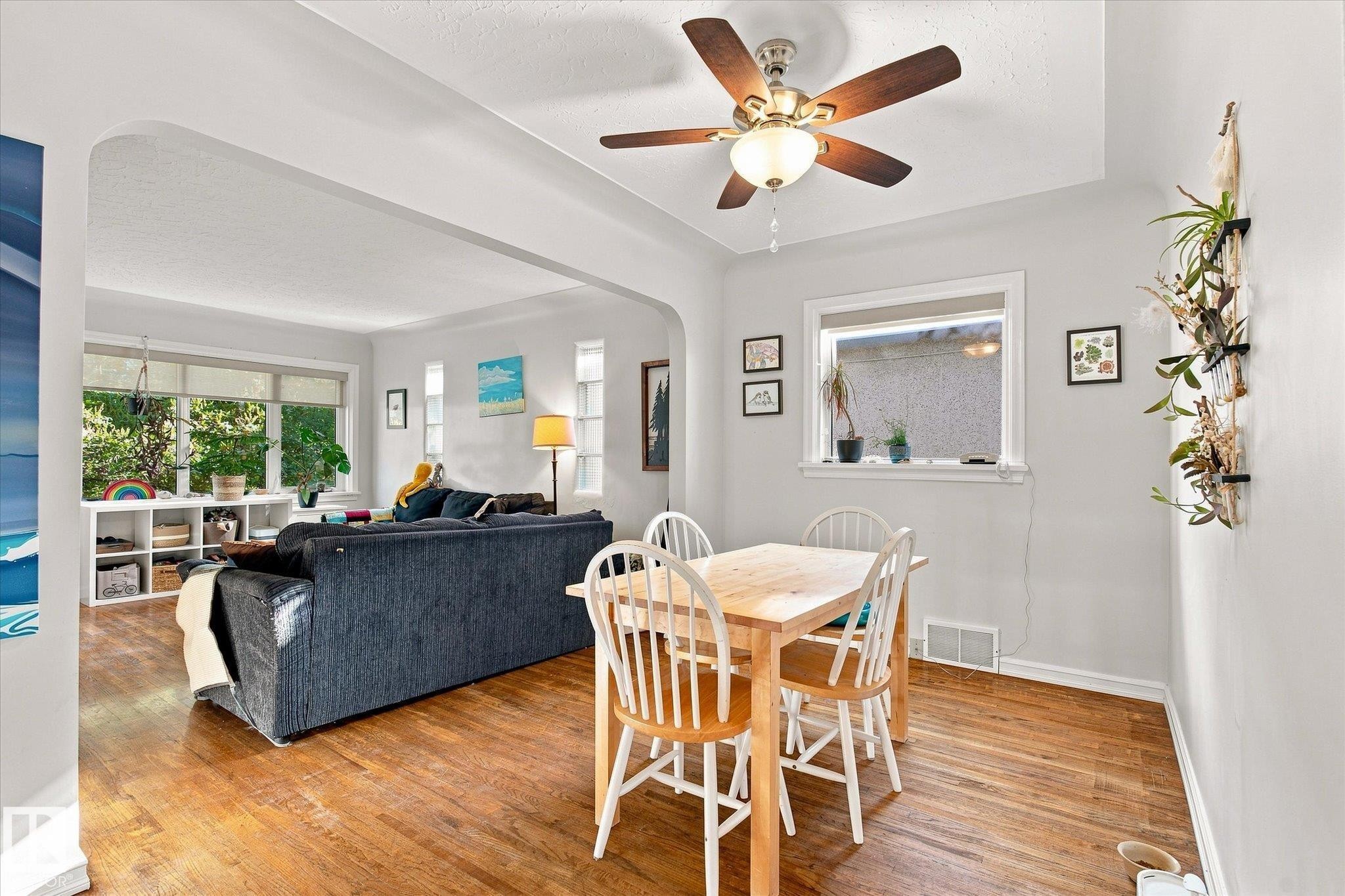 Hardwood-finish flooring throughout, with a ceiling fan with light fixture, and an arched doorway - 10943 72 Avenue Nw, Edmonton, AB