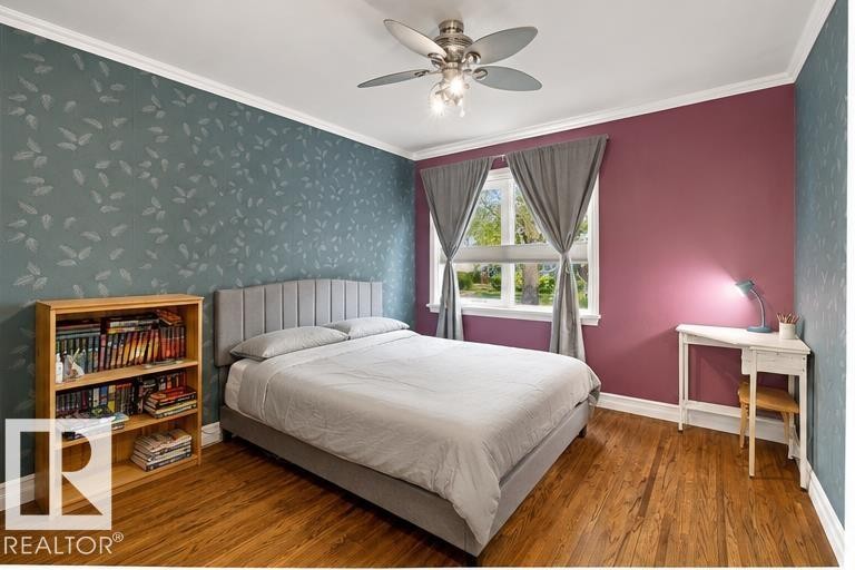 Wood-finish flooring, ceiling fan with integrated lighting, window with drapes, and crown molding - 10943 72 Avenue Nw, Edmonton, AB