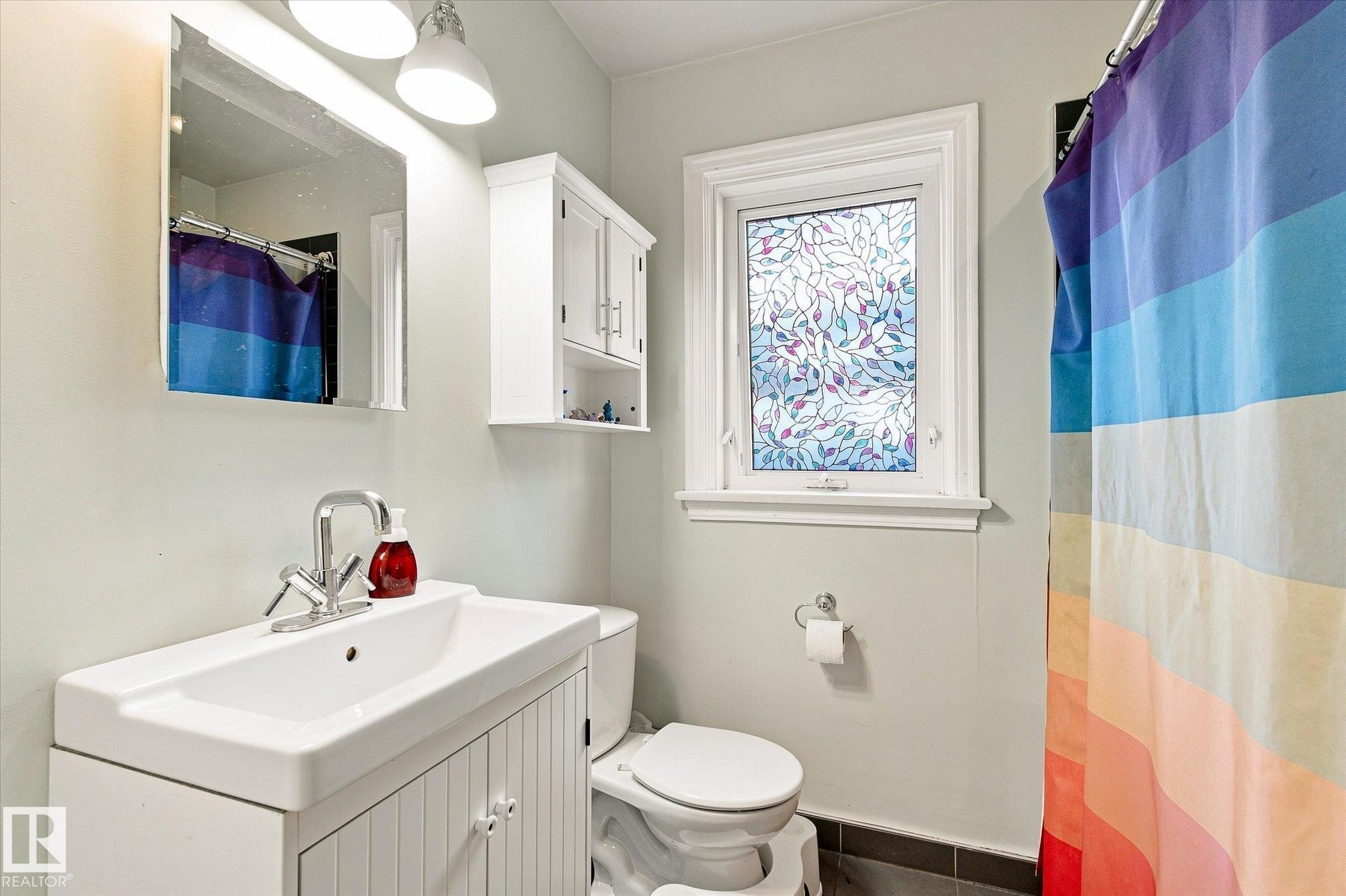 White vanity with an integrated sink and chrome faucet - 10943 72 Avenue Nw, Edmonton, AB
