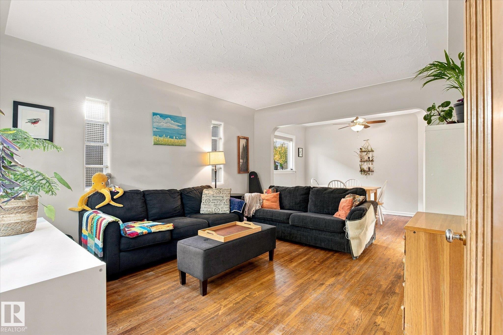 Warm wood-finish flooring extends throughout, complemented by arched entryway details - 10943 72 Avenue Nw, Edmonton, AB