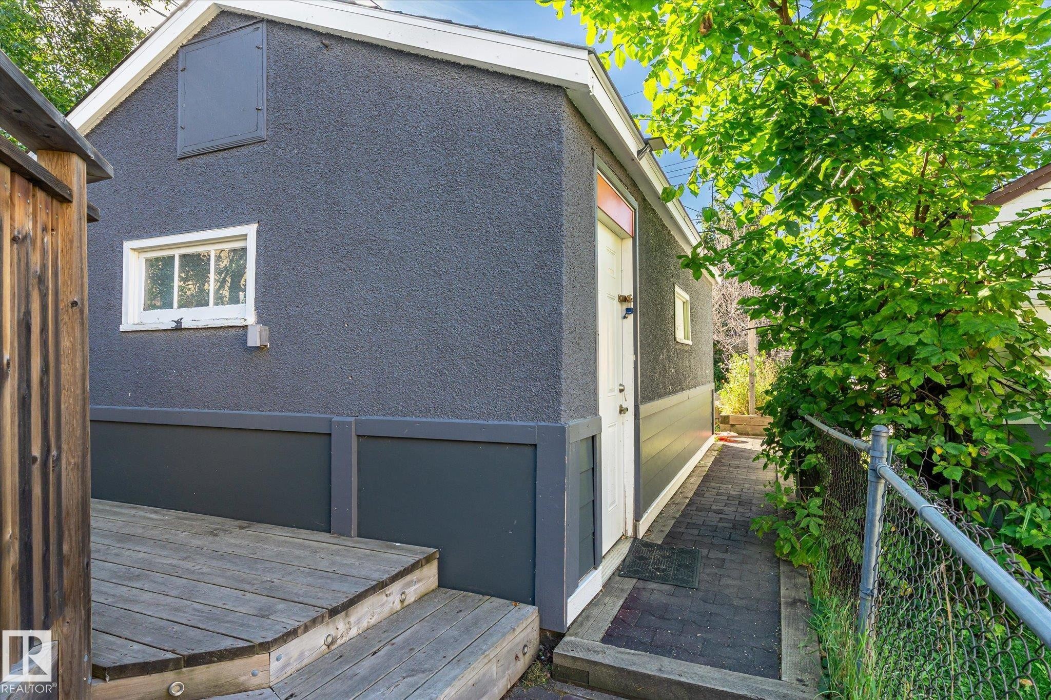 Exterior with textured grey stucco finish and white trim - 10943 72 Avenue Nw, Edmonton, AB