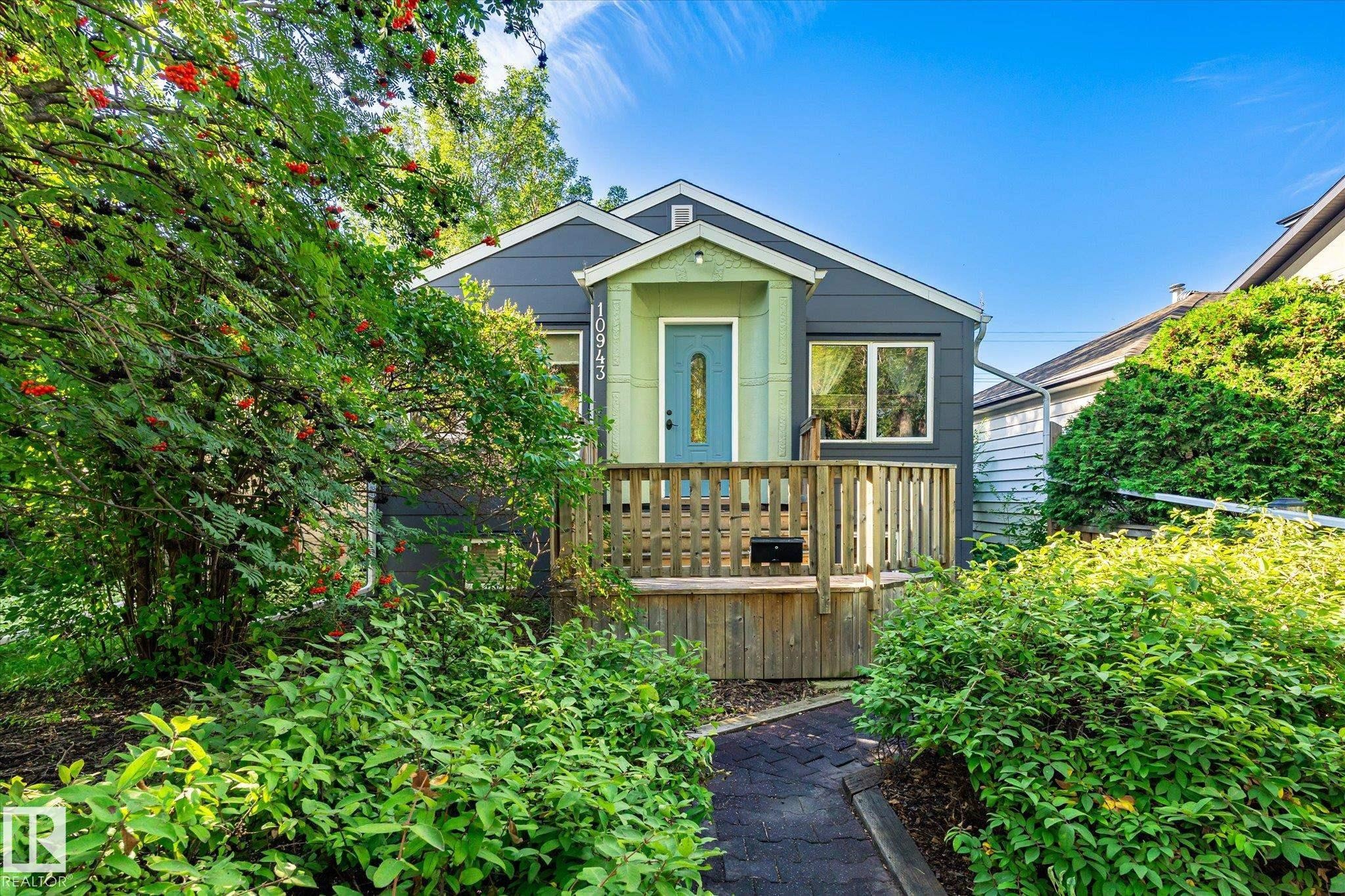 Front facade with a covered entry, wood-toned porch, and complementary siding - 10943 72 Avenue Nw, Edmonton, AB