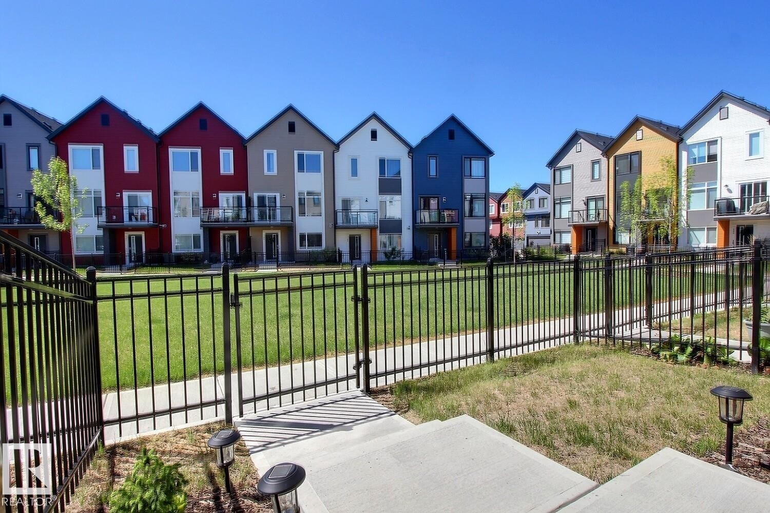 Row of contemporary townhomes featuring varied exterior colors and black-framed windows - #99 1010 Rabbit Hill Rd Sw, Edmonton, AB