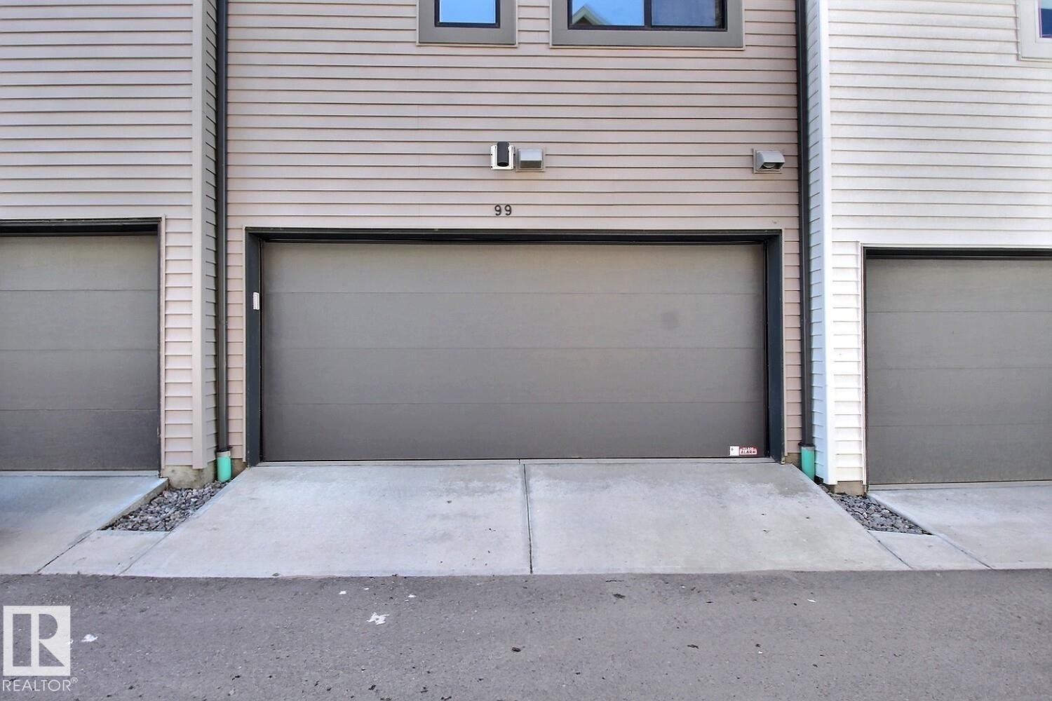 Attached single-car garage featuring a grey overhead door - #99 1010 Rabbit Hill Rd Sw, Edmonton, AB