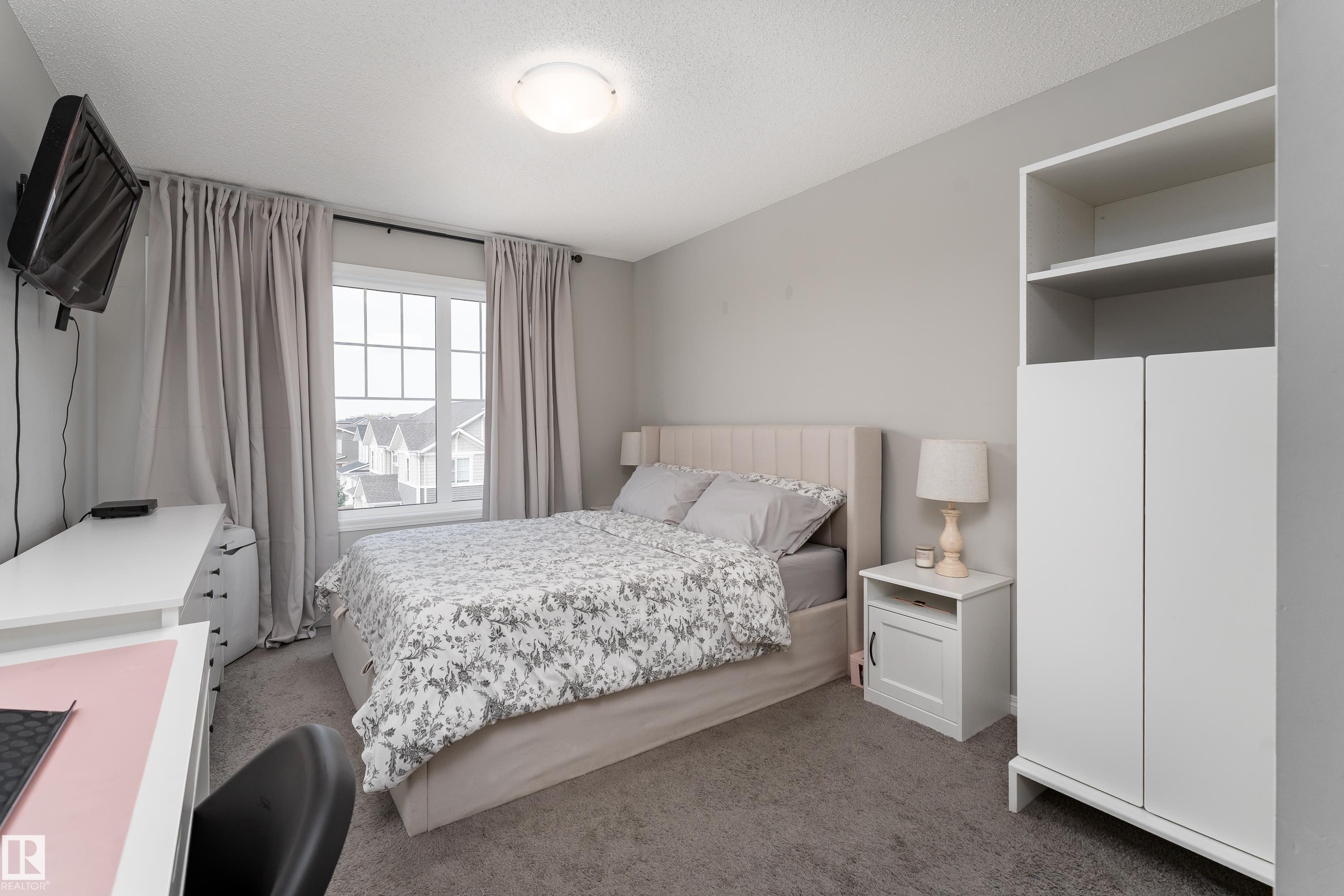 Carpeted room with a multi-pane window and neutral wall color - 20247 16 Avenue Nw, Edmonton, AB