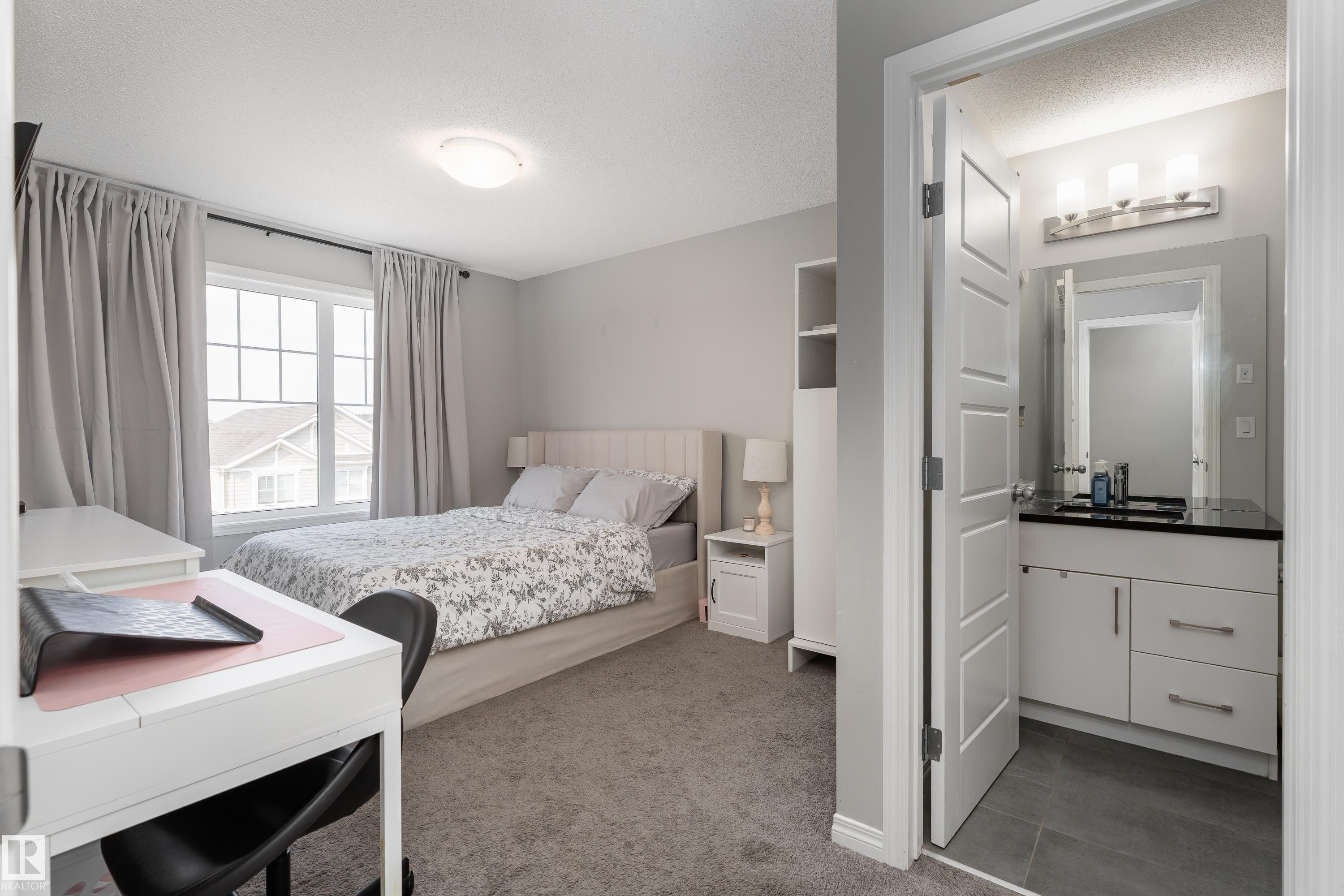 Carpeted bedroom with a window featuring grid panes - 20247 16 Avenue Nw, Edmonton, AB