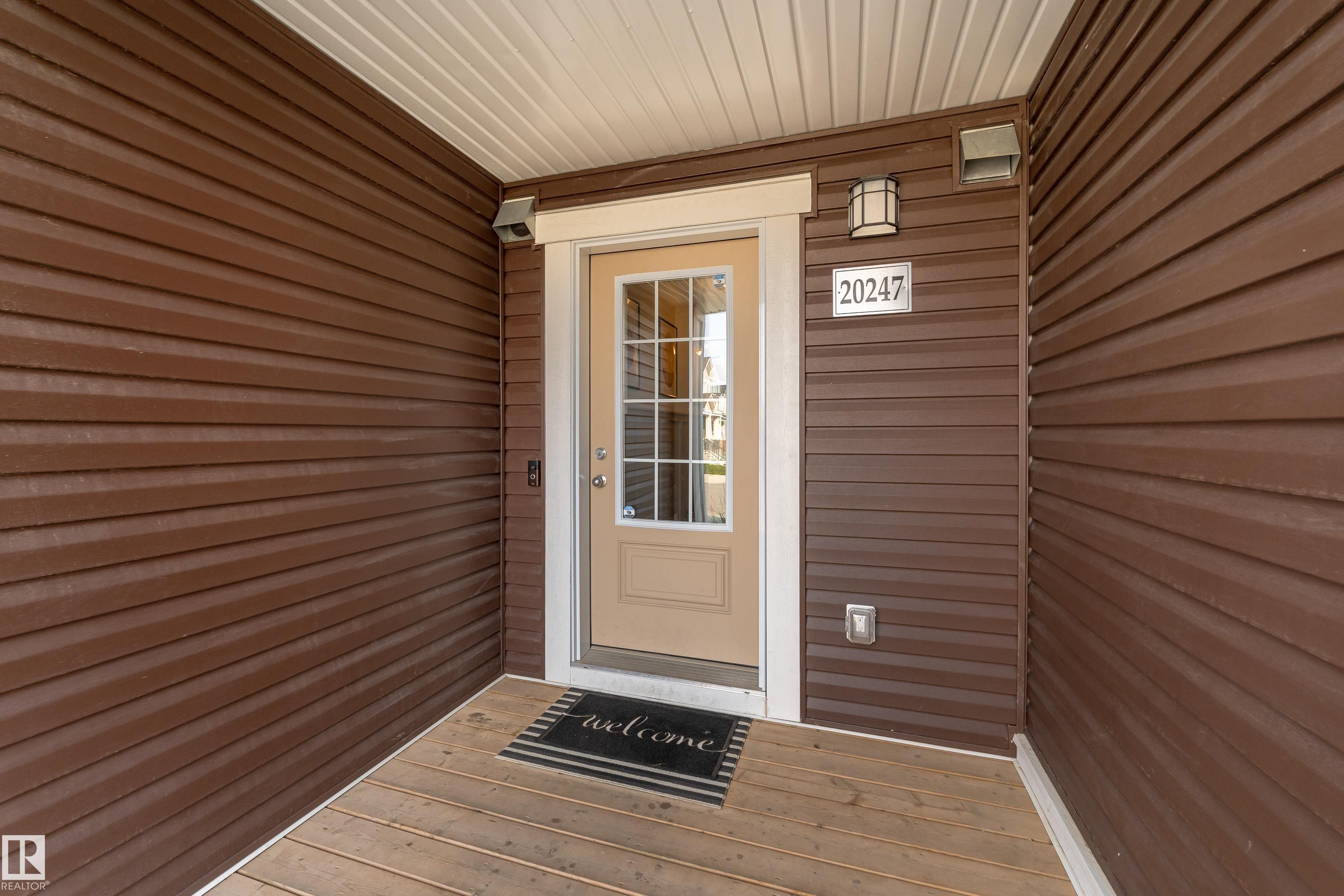 Brown horizontal siding exterior with a wood-finish porch floor - 20247 16 Avenue Nw, Edmonton, AB