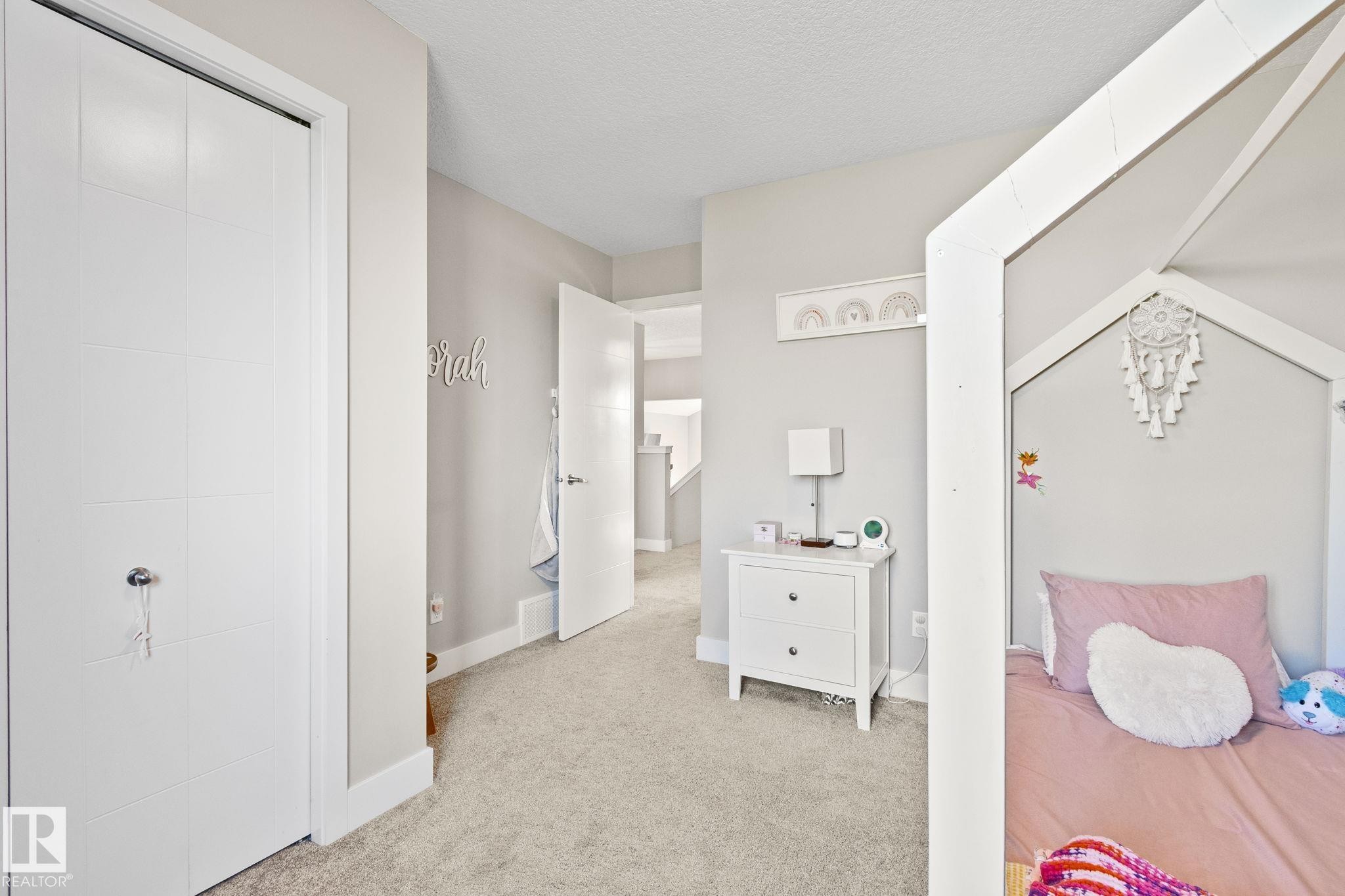 Soft neutral wall paint with white trim, light-colored carpeting, and a white interior door - 2096 Redtail Common Nw, Edmonton, AB
