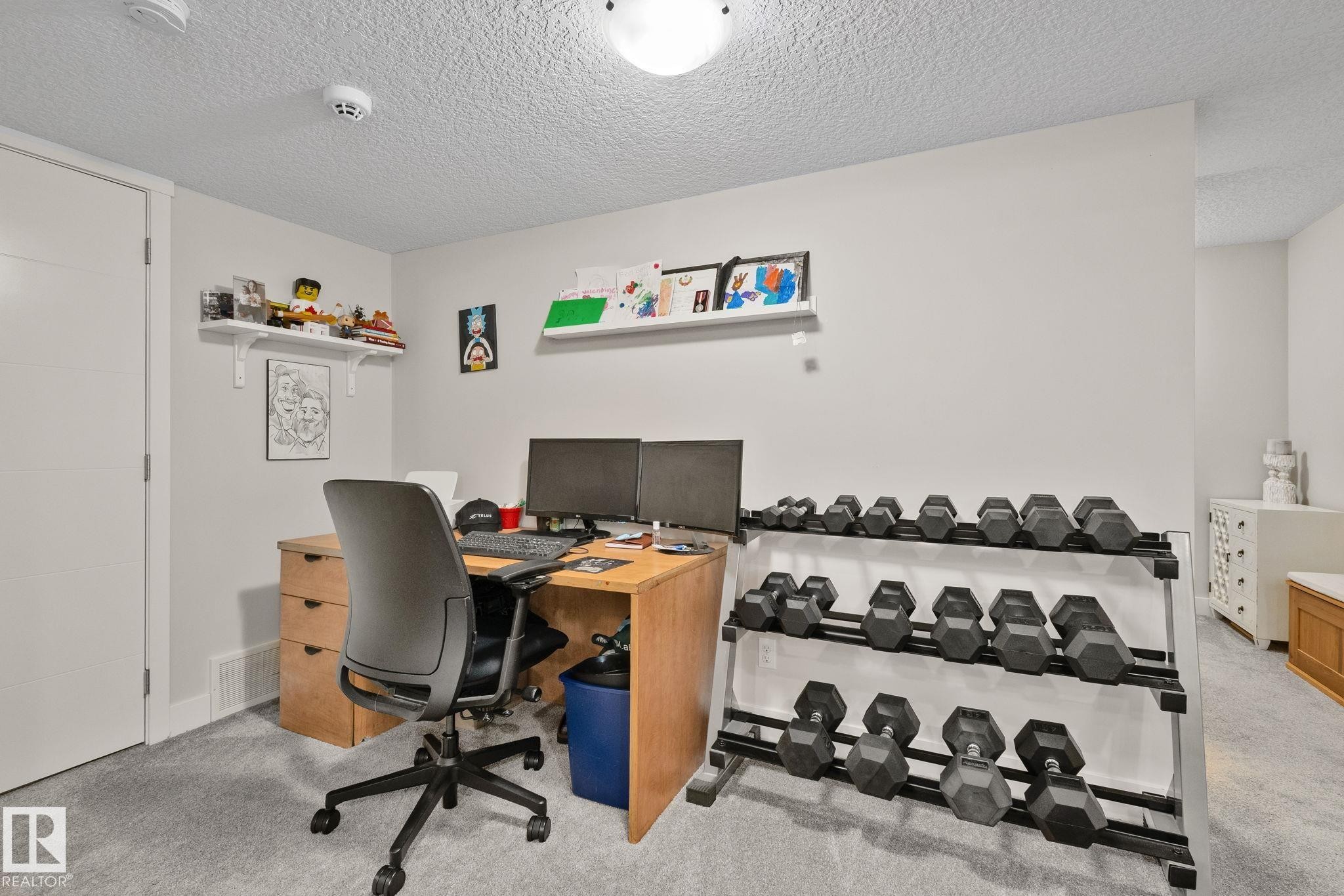 Spacious room with light gray walls, textured ceiling, and light gray carpeting - 2096 Redtail Common Nw, Edmonton, AB