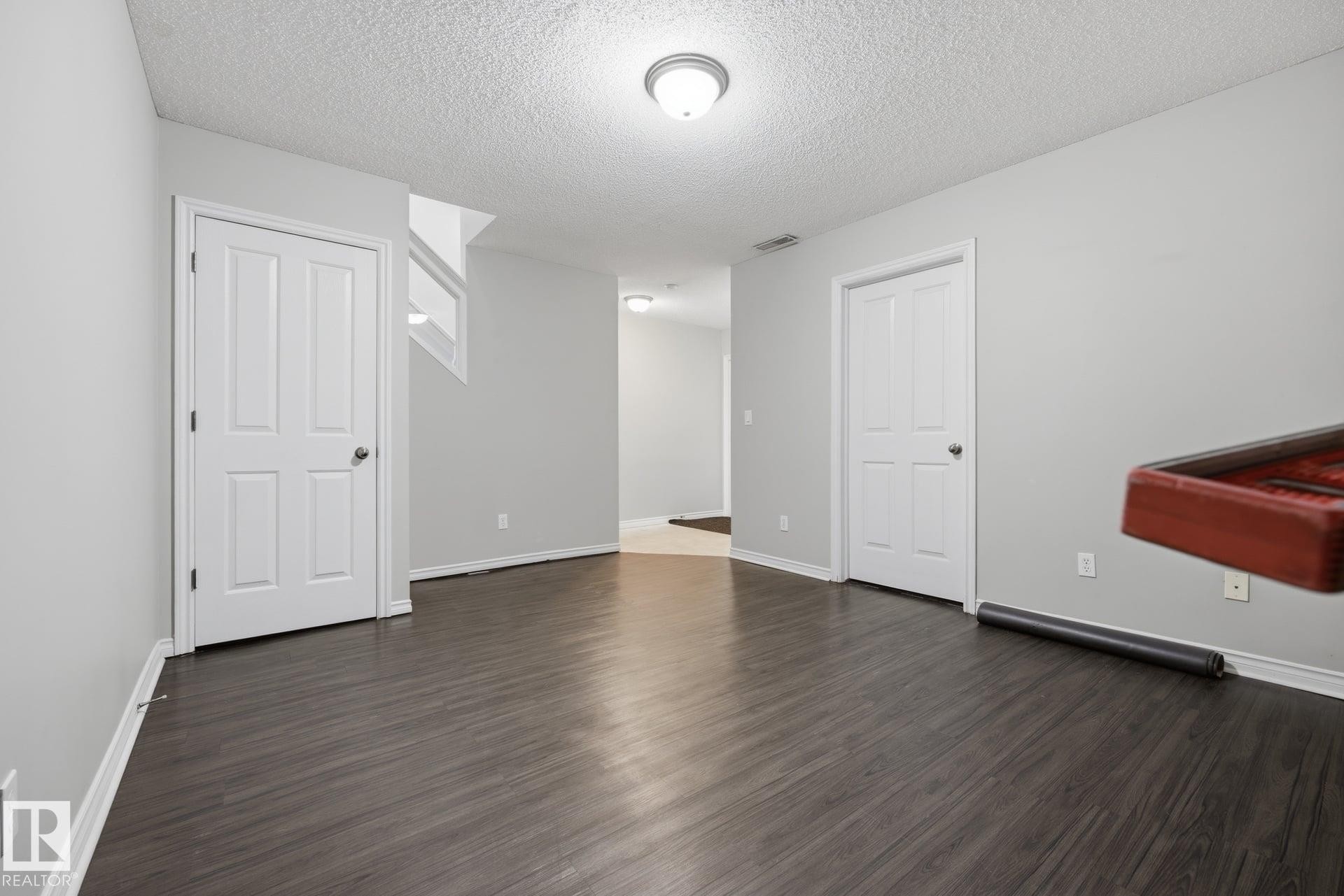 Wood-finish flooring with light gray walls and white trim - #102 13825 155 Av Nw, Edmonton, AB
