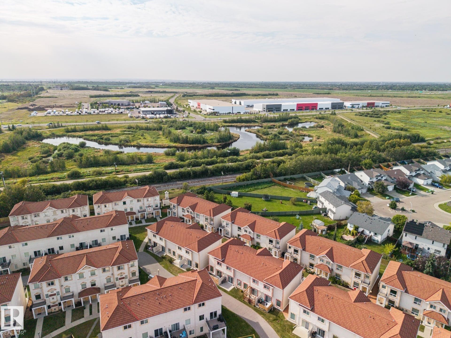 Red tile roofs and light-colored facades - #102 13825 155 Av Nw, Edmonton, AB