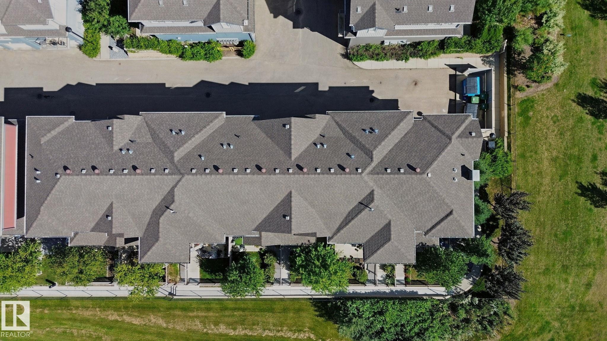 Townhome property featuring a shingle roof and multiple skylights - #58 4029 Orchards Dr Sw, Edmonton, AB